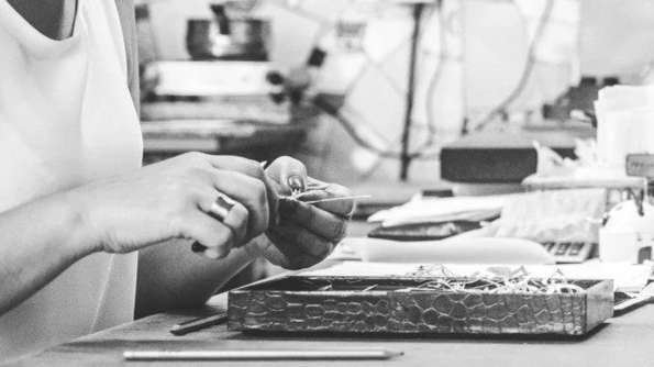 Pessoa trabalhando com ferramentas em uma bancada de oficina.