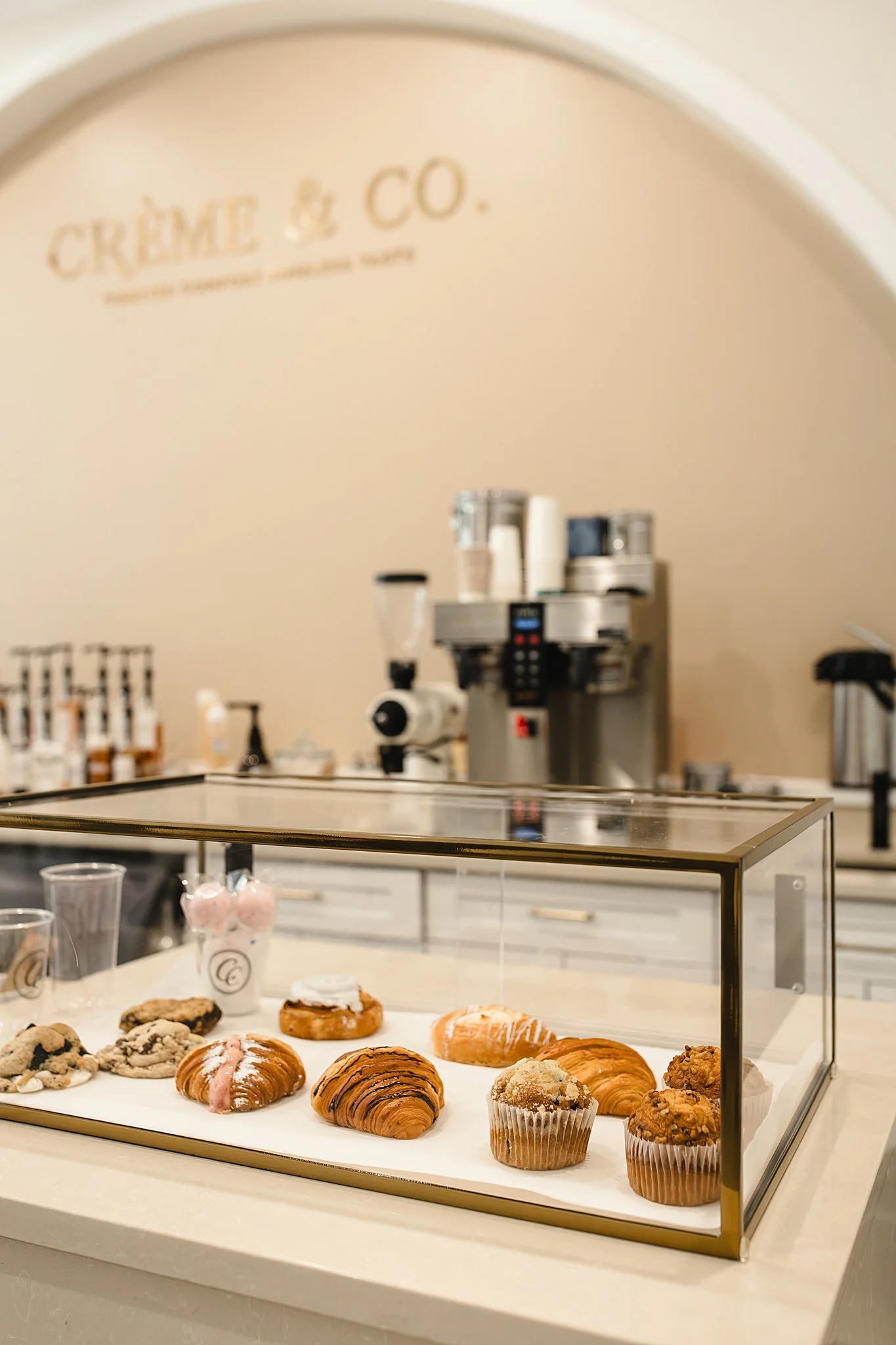 Display case with assorted baked goods such as croissants, muffins, and cookies in a bakery or cafe setting during branding photography near me.