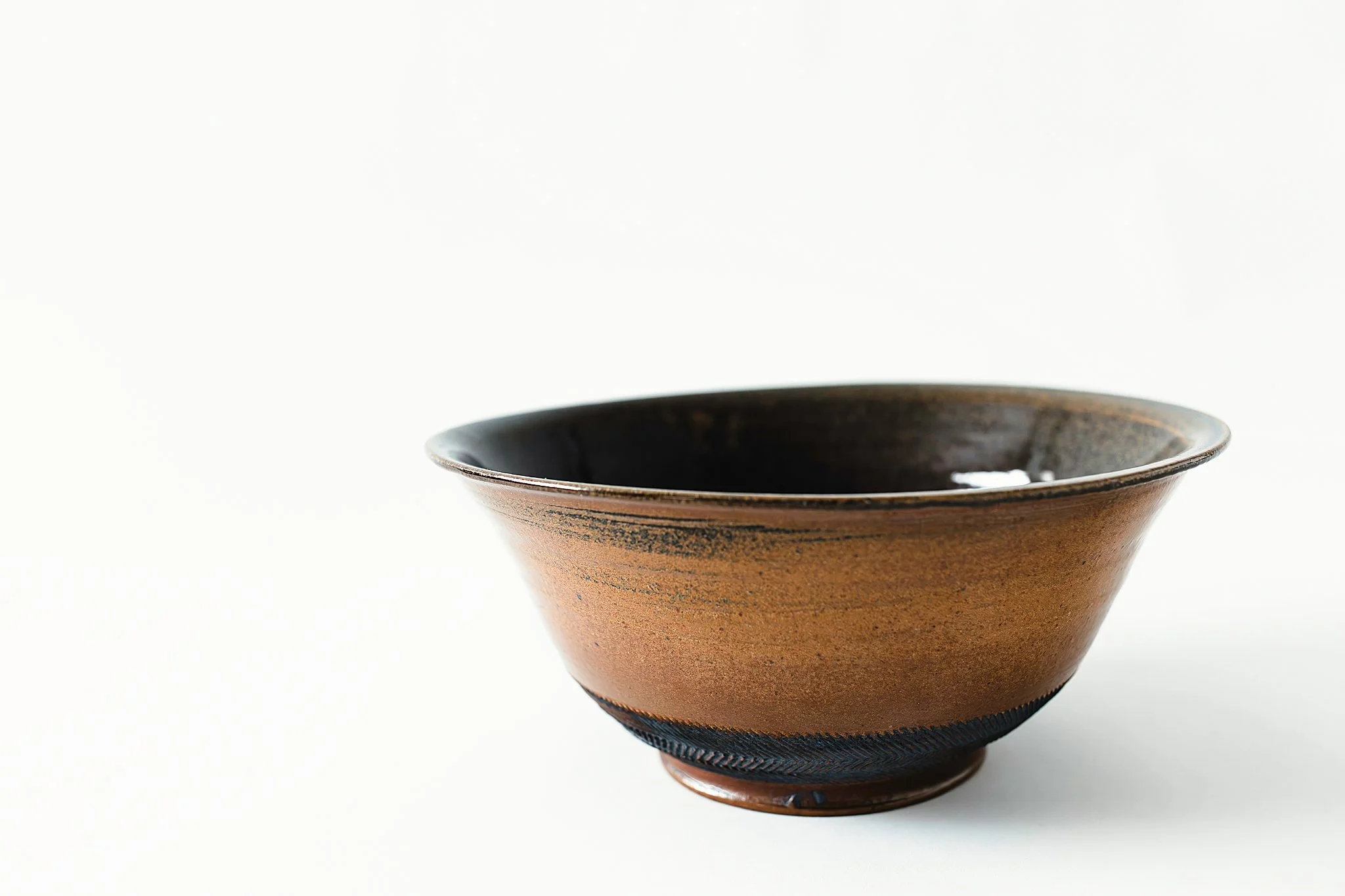 Brown ceramic bowl with black interior on a white background during a product photo with Ally and B Photography in Naperville, IL.