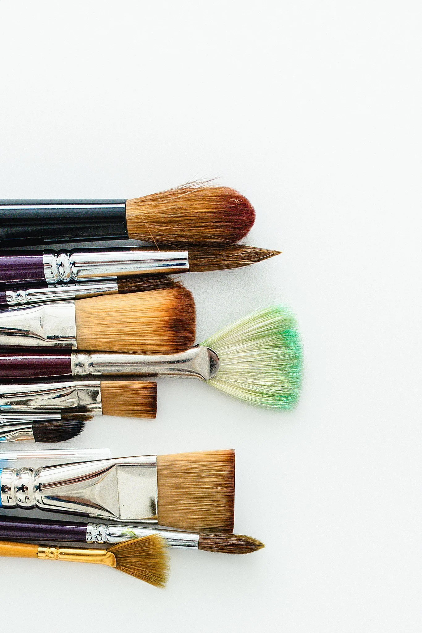 Collection of makeup brushes on a white background for product photography.