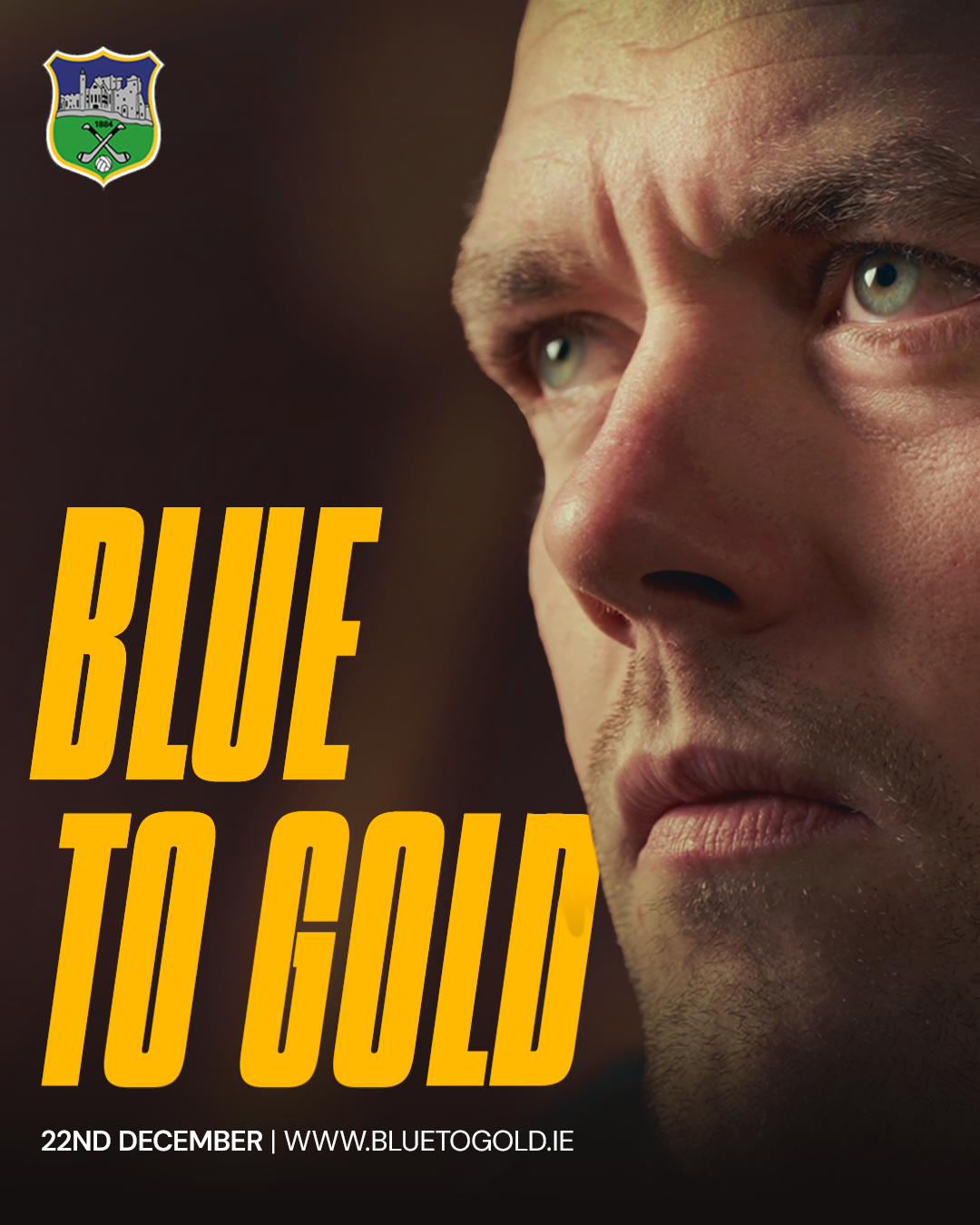 Close-up of a man's face with serious expression, light skin, short hair, and piercing blue eyes, with text saying "Blue to Gold" and event details for December 22nd.