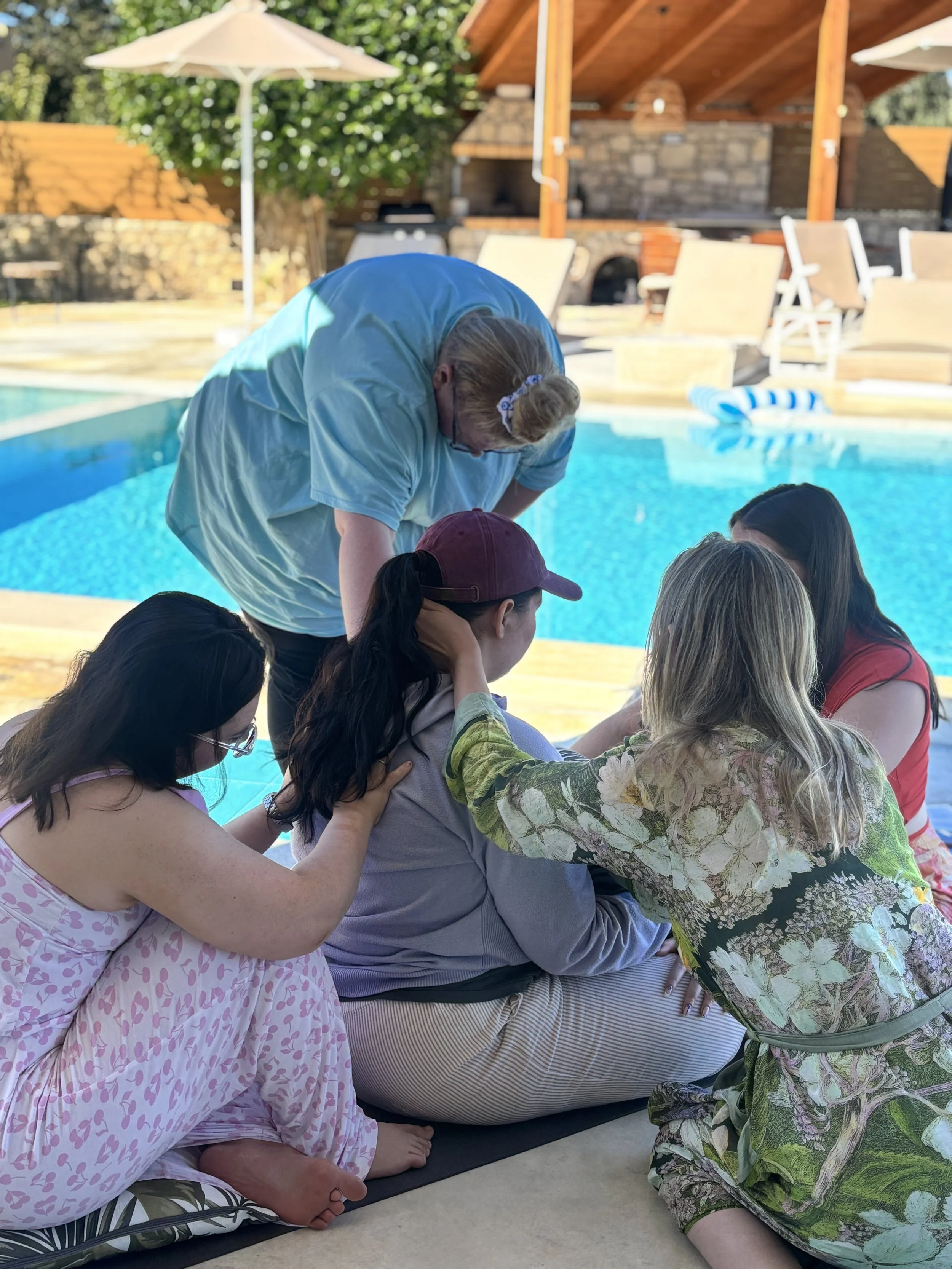 group community of women holding another woman as she processes huge trauma. healing in community. remembering wholeness.