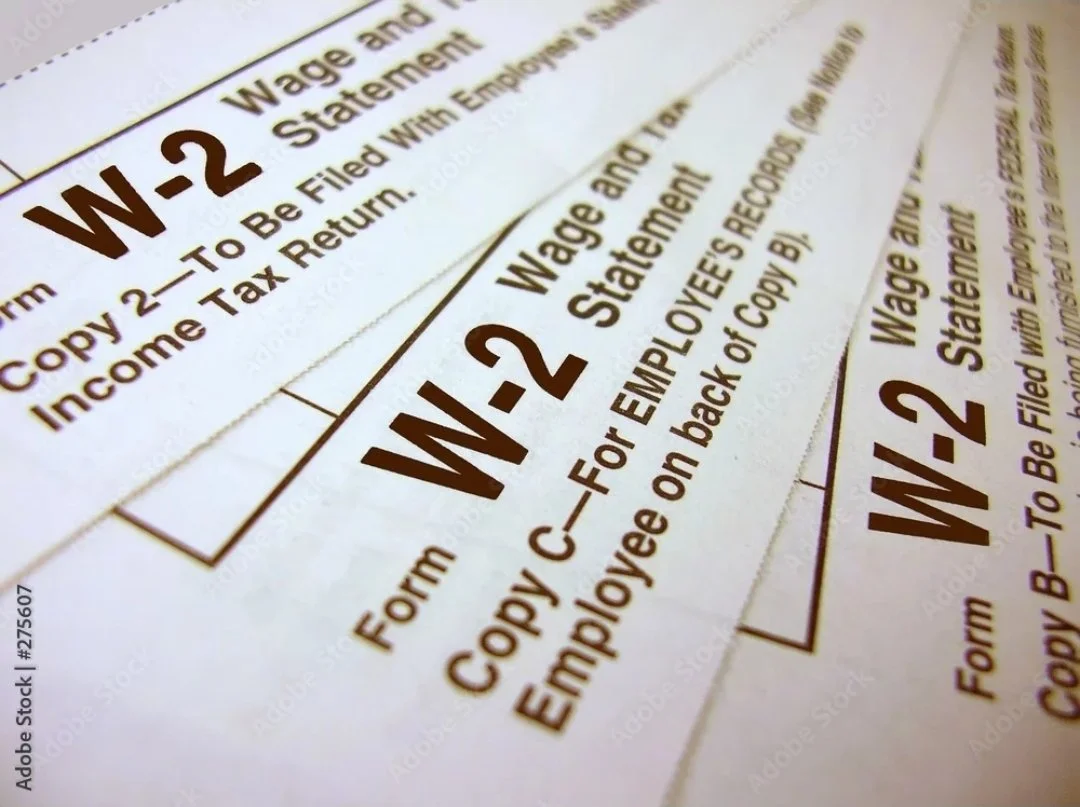 Close-up of multiple W-2 tax forms with bold headings, showing instructions for filing employment income and tax return paperwork.