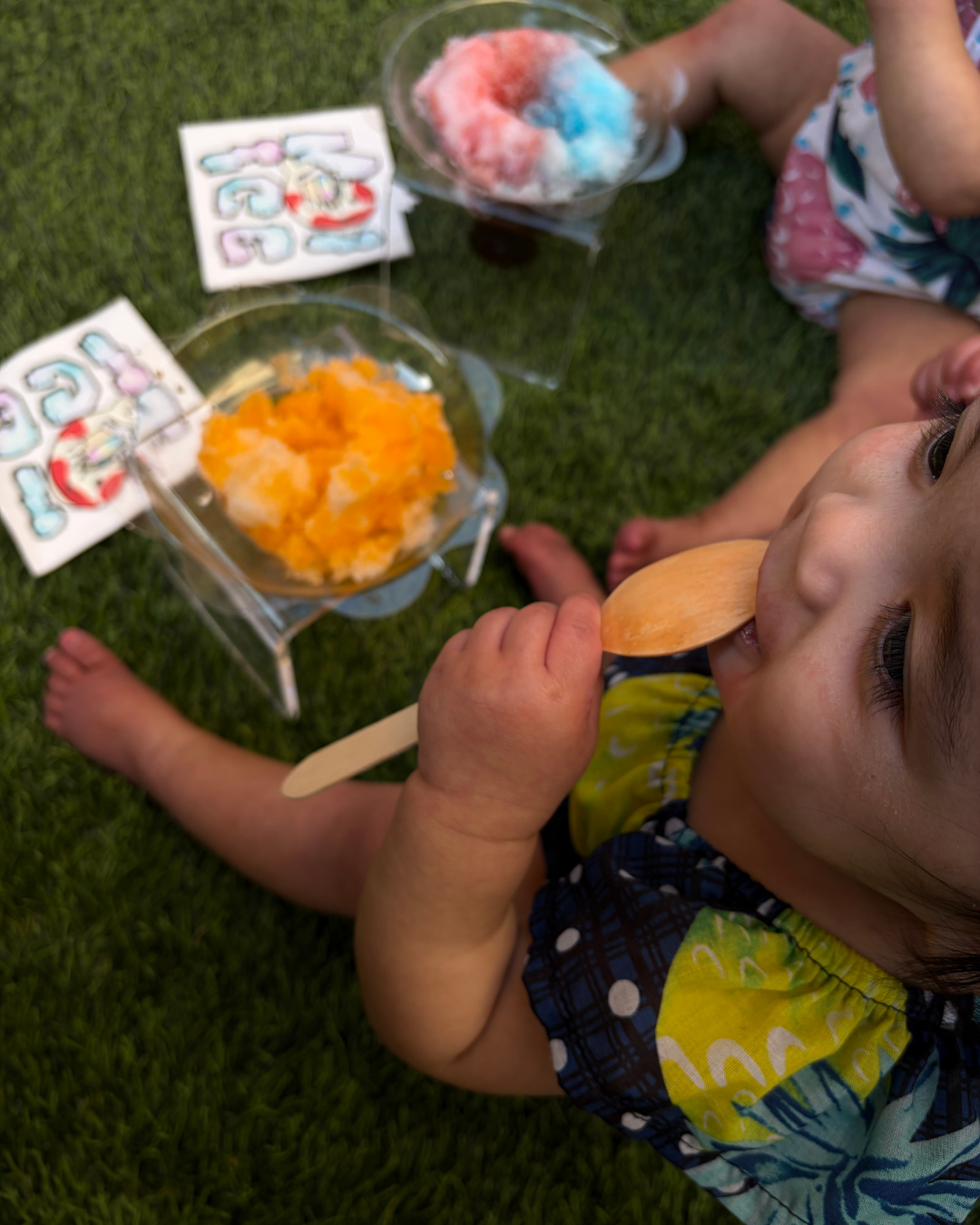 Kids enjoying rainbow shaved ice on a warm sunny day