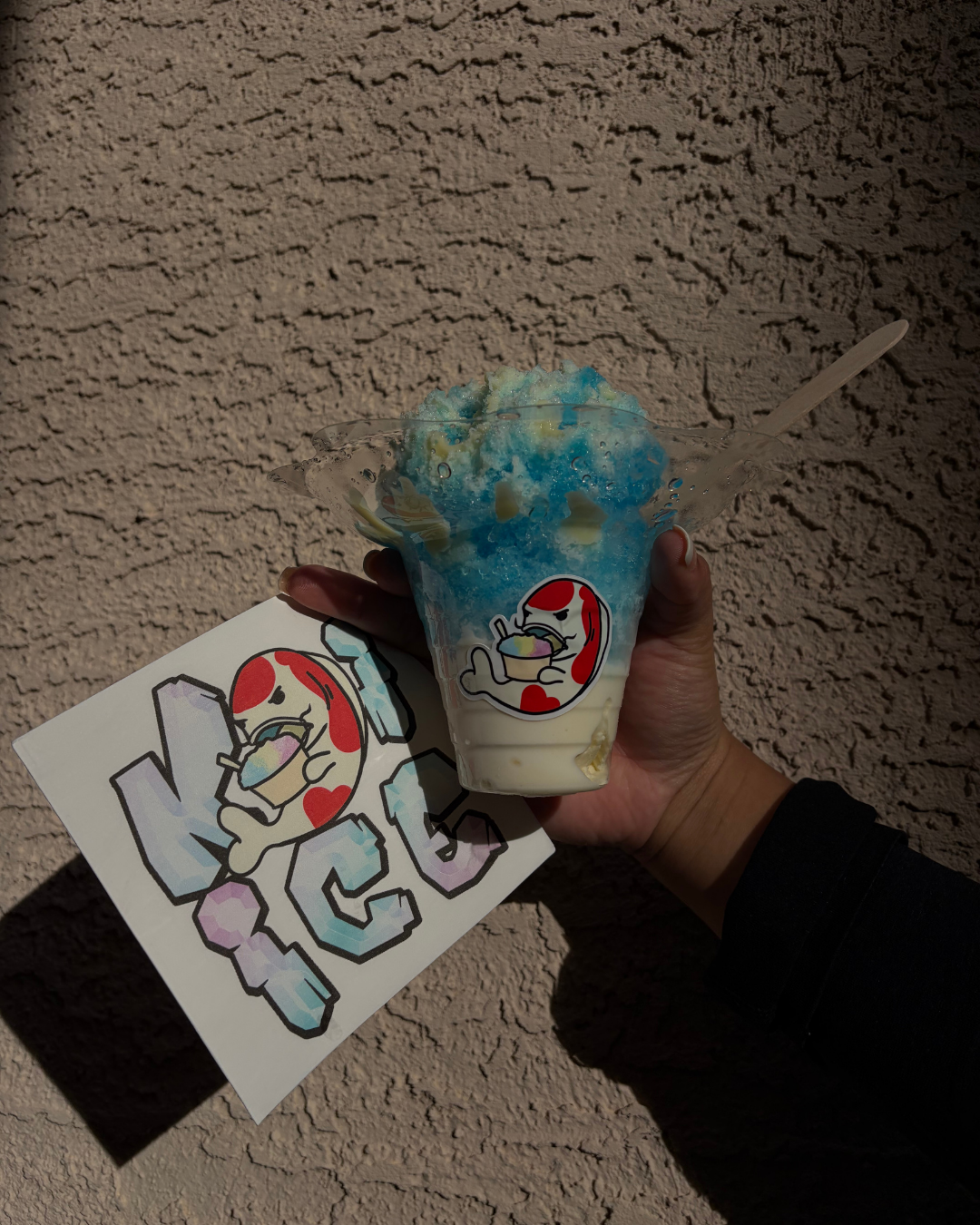 Premium shaved ice with vibrant syrups piled high in branded Koi Ice cups