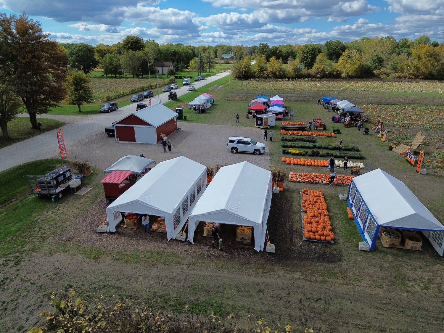 Aerial drone photo of tents, pumpkins, and barns at Tipper Farms Harvest Fest in East China Township, Michigan