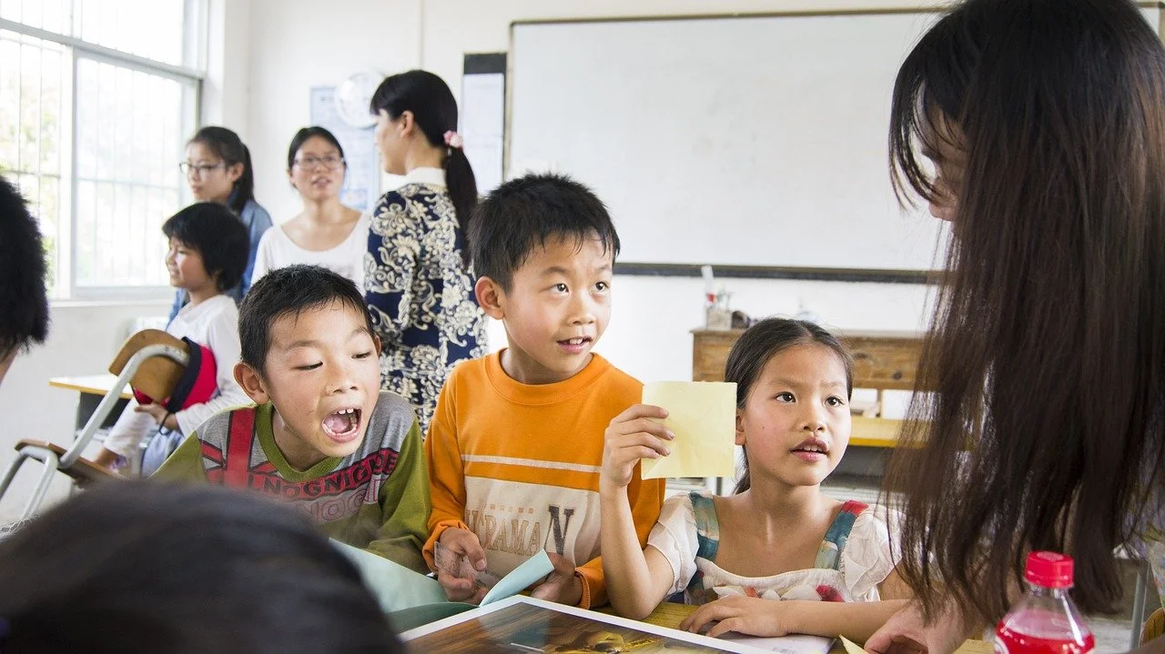 Children interacting with a teacher in a classroom setting