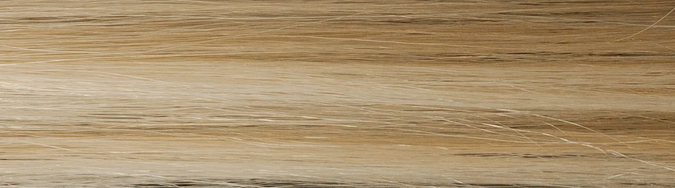 Close-up of a light-colored wooden surface or flooring with visible grain patterns.