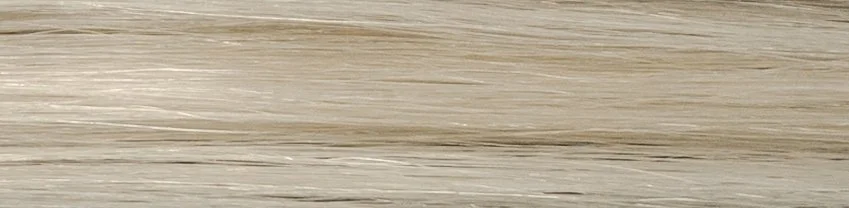 Close-up of a wooden surface, showing light and dark wood grain patterns.
