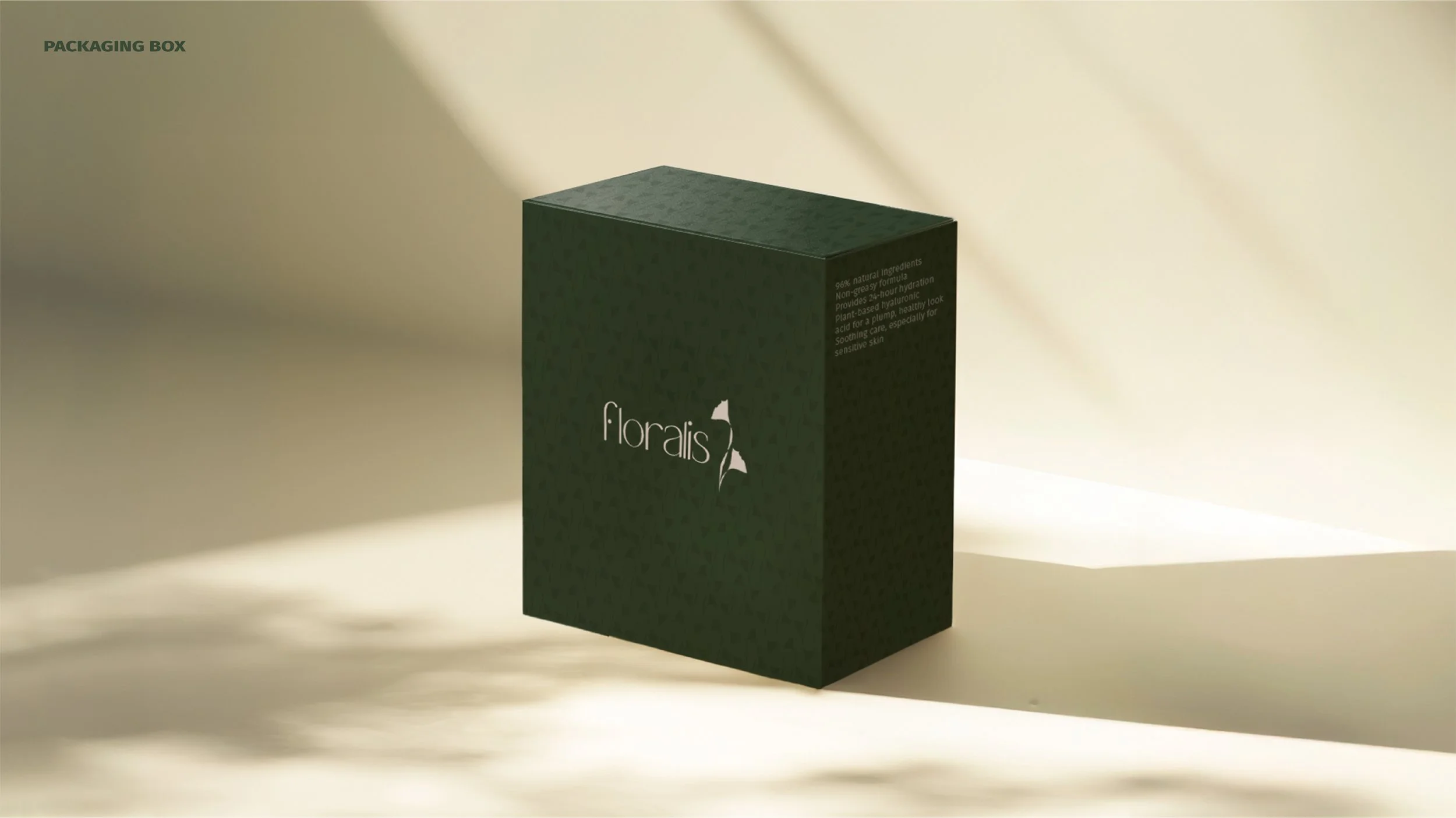 A green box labeled 'Floralis' with a small white floral logo, placed on a surface with light and shadow patterns.