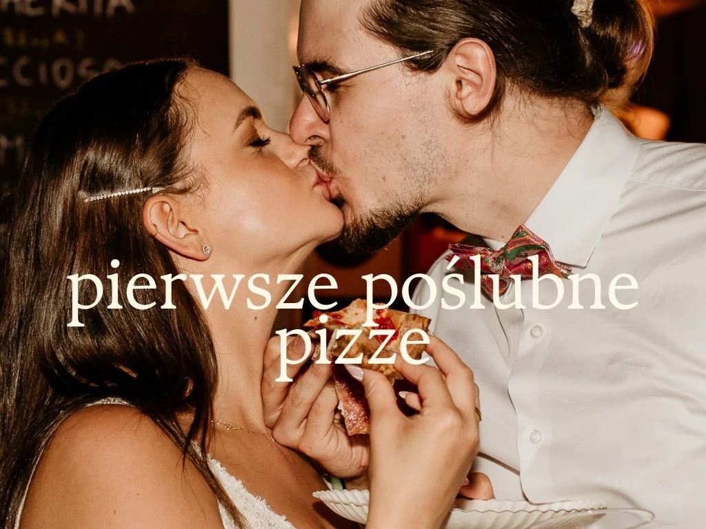 A couple sharing a kiss while holding a slice of pizza with a woman in a white dress and man in a white shirt and bow tie