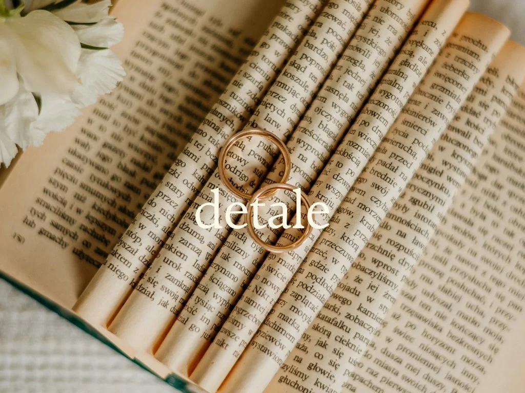 Open book with two gold wedding rings and white flower bouquet on pages of text.