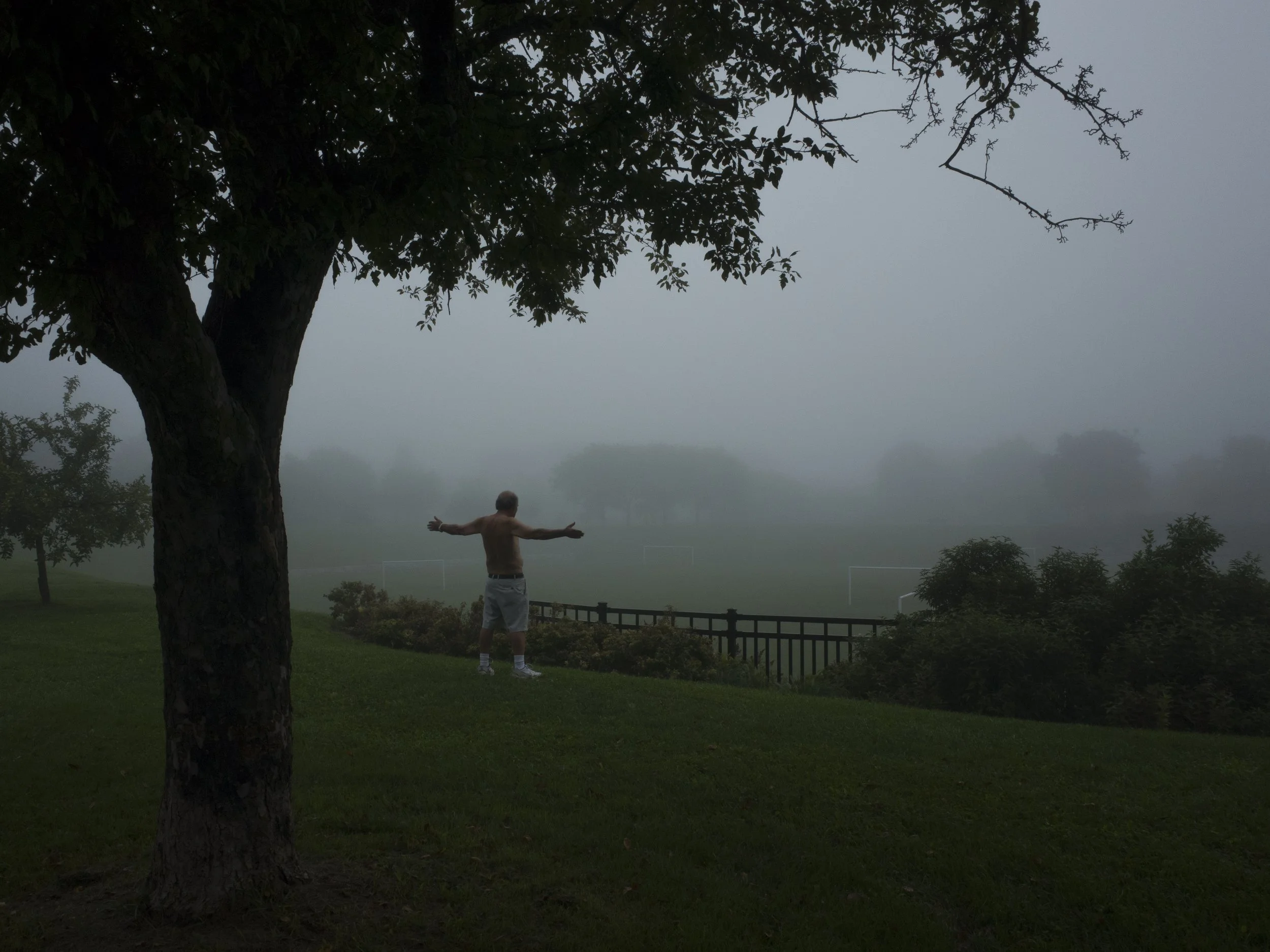 A man standing on a field with his arms outstretched.