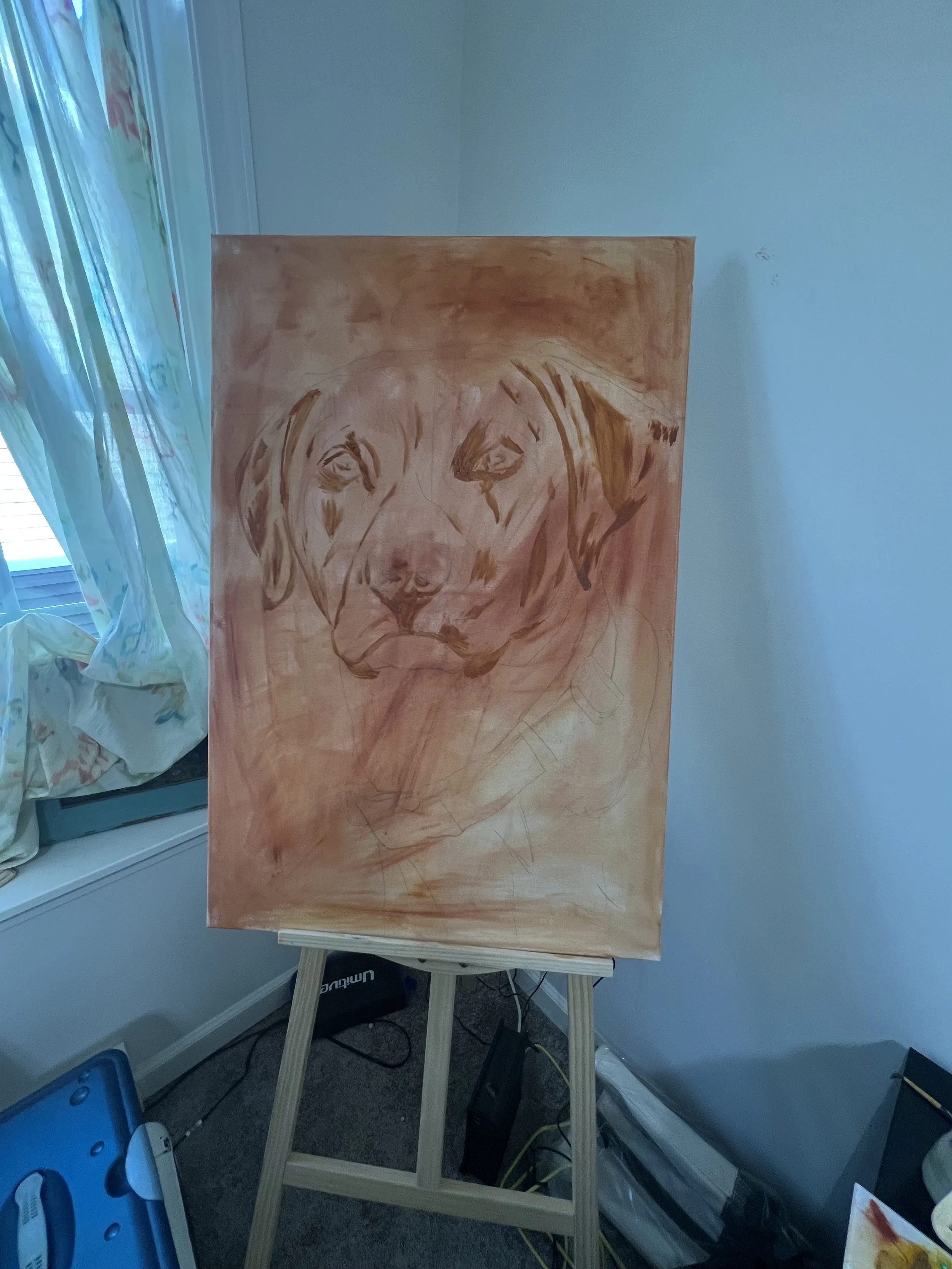 Unfinished painting of a dog's face on an easel in a room, with a window and curtains to the left.