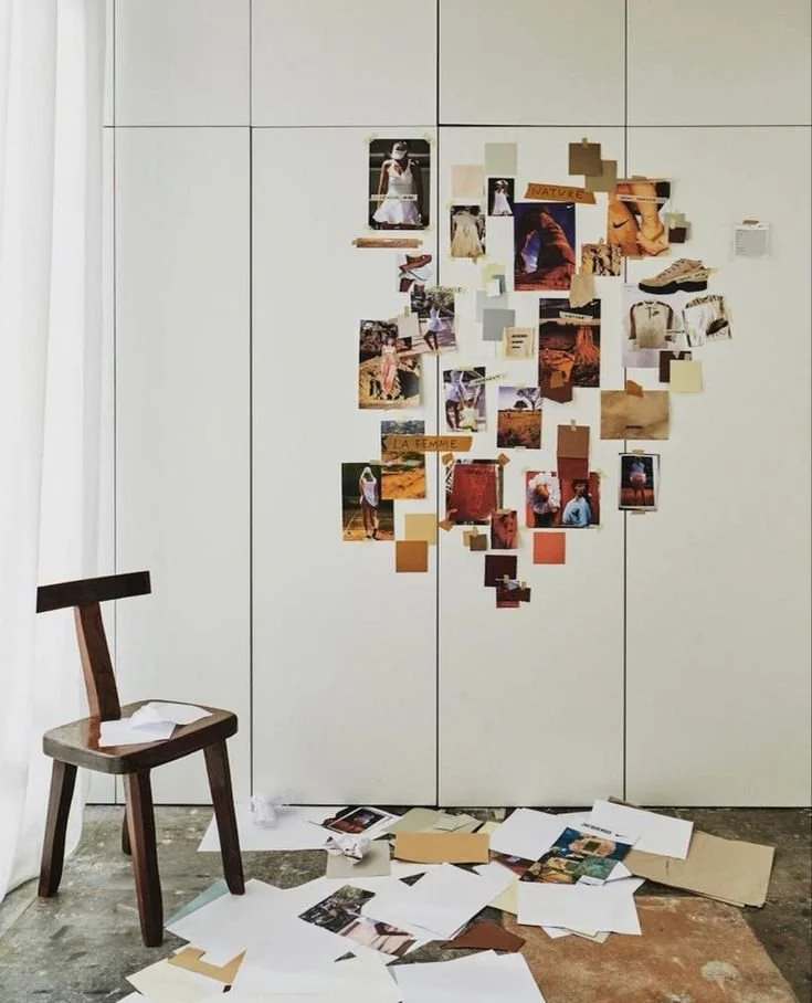 Mur blanc avec un collage de photos et de papiers, un chaise en bois à gauche, papiers éparpillés au sol, représentant la création de projet de Treize Zéro Trois