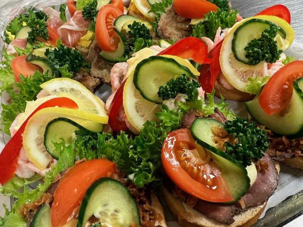 Smørbrød med kjøtt, salat, tomat, agurk og sitron.