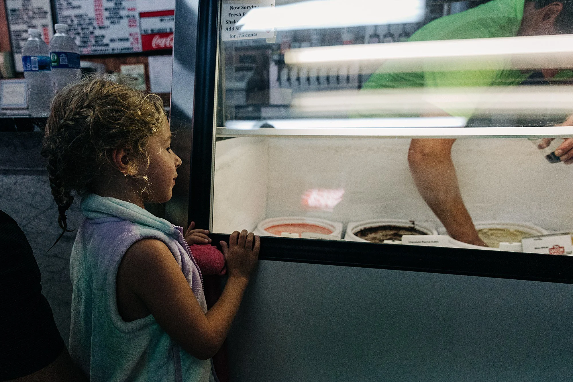 young girl watches as employee scoops ice cream