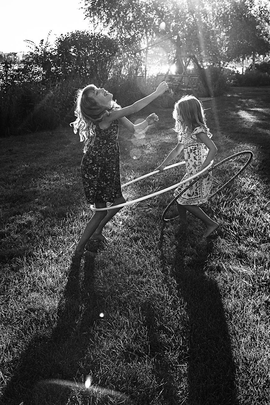 two girls play hula hoop in beautiful light