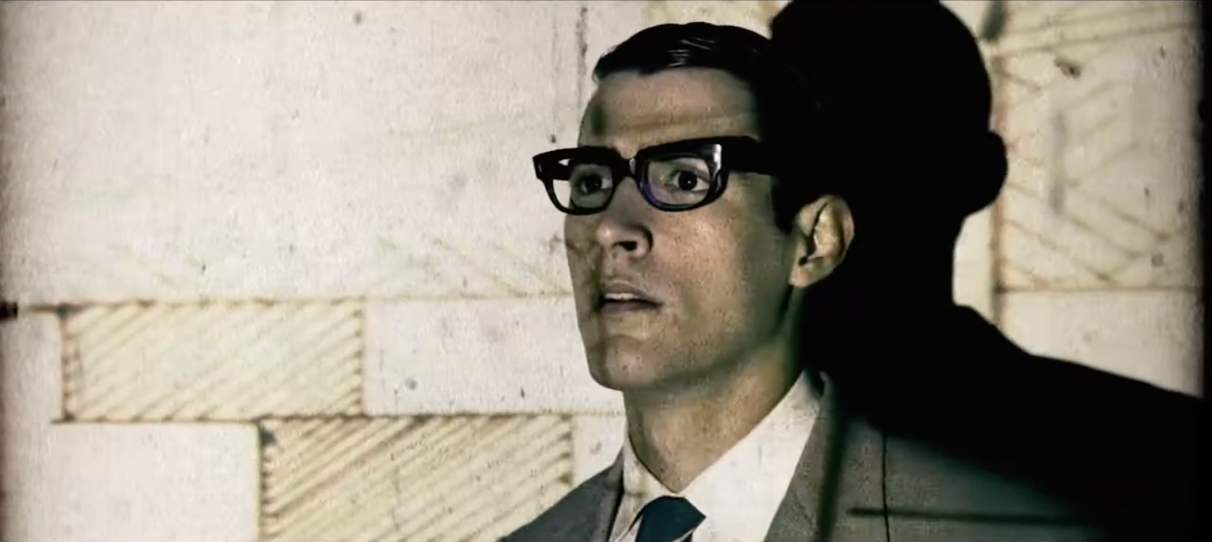 Patricia Machin Portfolio Designer Art director Miami A man with glasses and a suit stands against a brick wall.