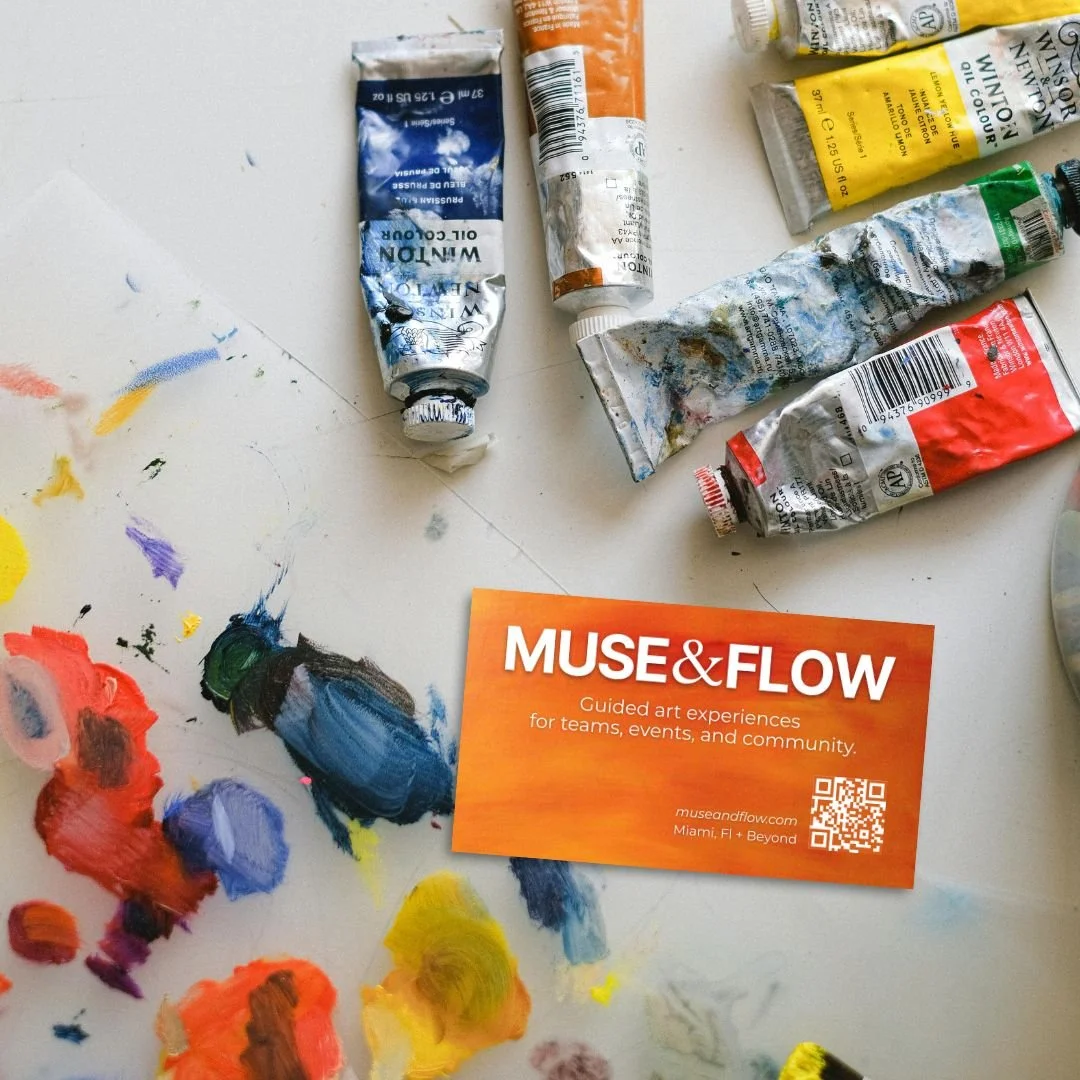 Patricia Machin Portfolio Designer and Art Director Assorted oil paints in tubes and color swatches on a white surface, with an orange business card for Muse & Flow promoting guided art experiences in Miami, Florida.
