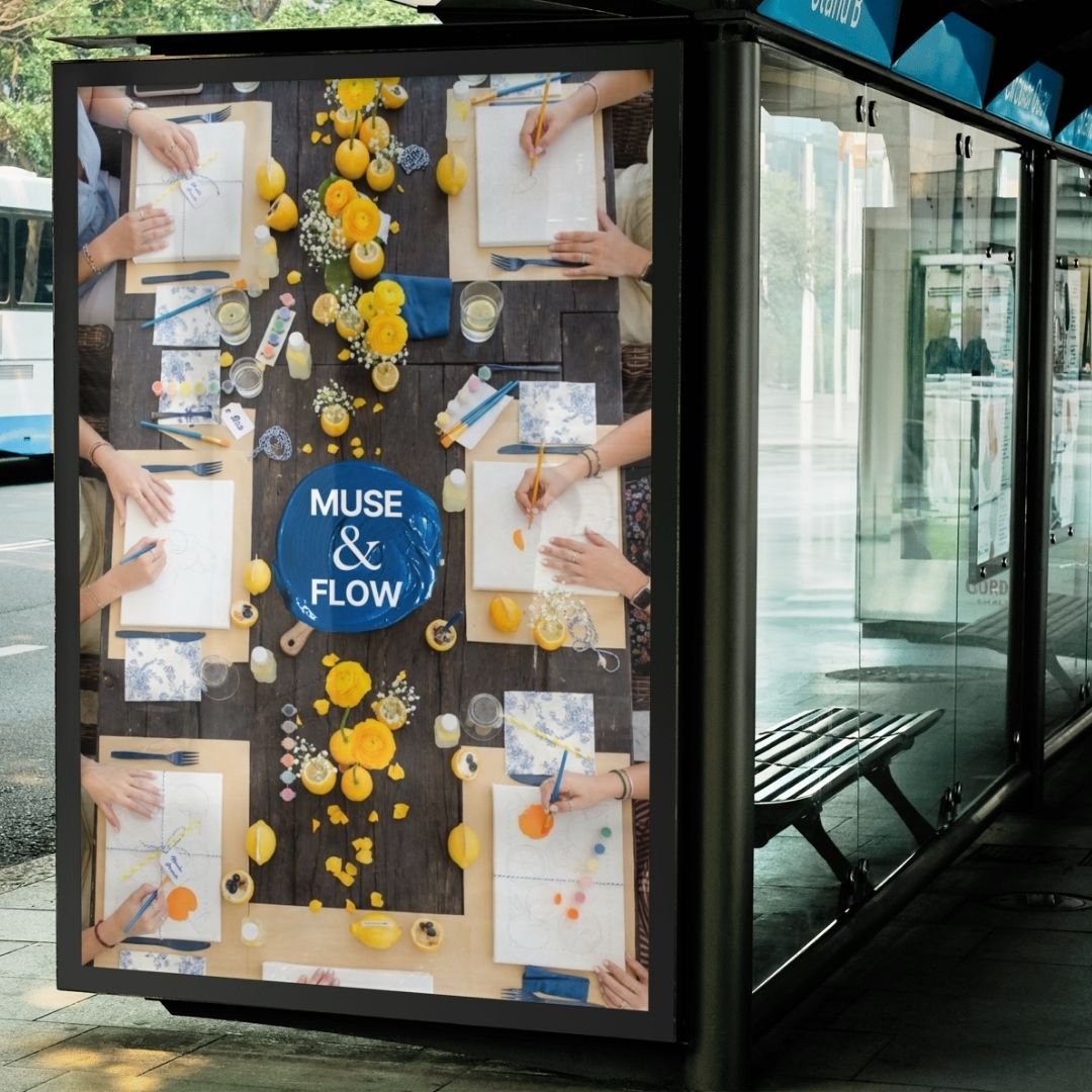 Patricia Machin Portfolio Designer and Art Director People sitting around a table decorating pumpkins with yellow flowers, paint, and markers, with a blue plate with the words "MUSE & FLOW" in the center.