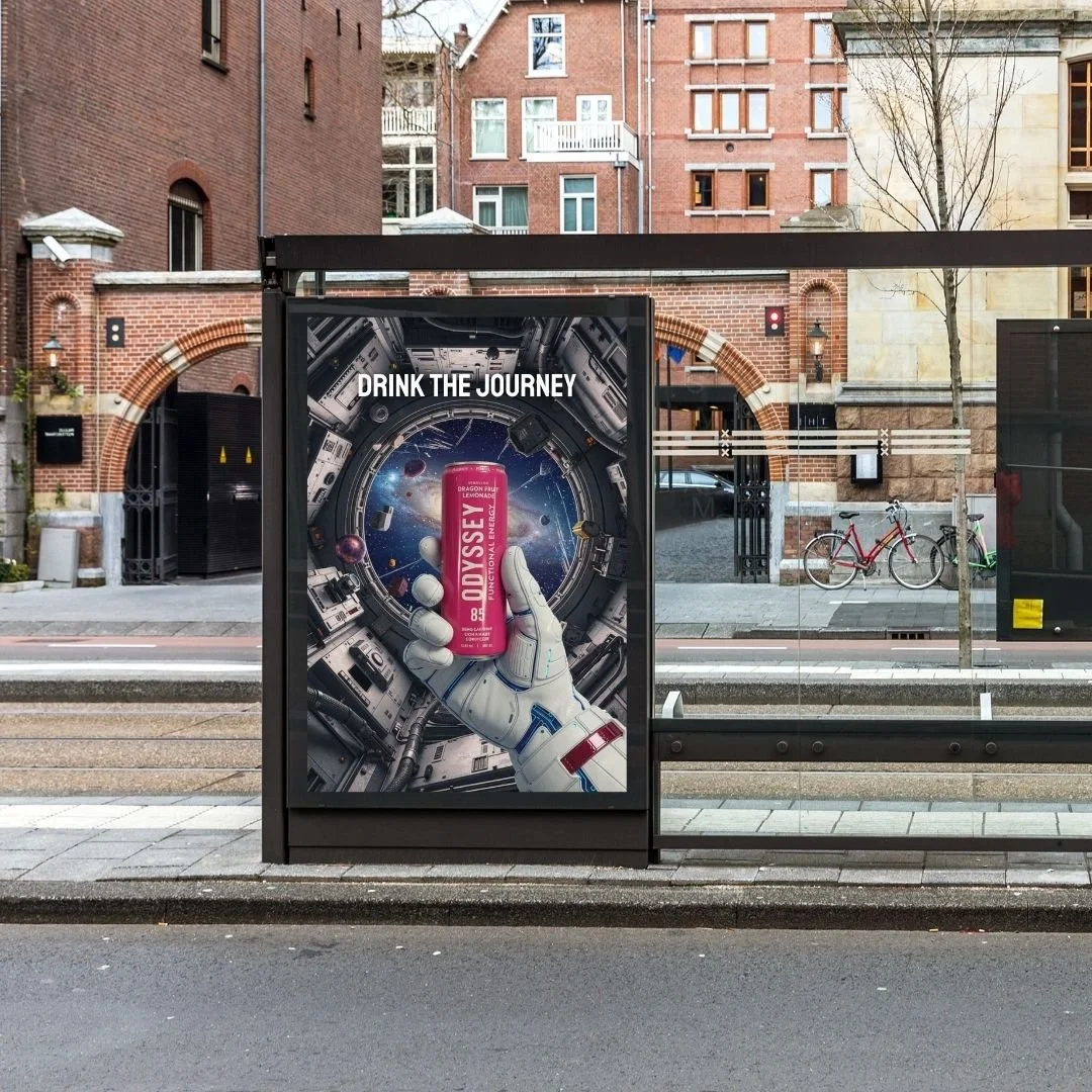 Patricia Machin Miami Portfolio Designer Art Director  Bus stop advertisement featuring a space-themed background with a hand in a space suit holding a pink can of Odyssey lemonade, and the text 'Drink the Journey'