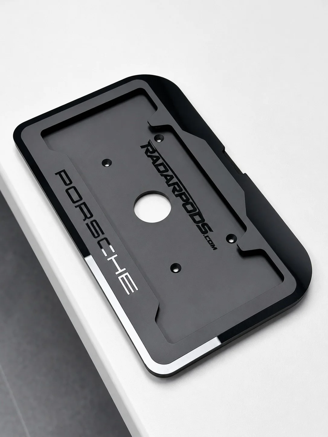 Stealth. Function. OEM inspired fitment. 

The Radarpods Uniden Laser Transponder License Plate Frame for Porsche 911 991.1/991.2 models features a removable IR acrylic cover, hidden transponder integration, and retained tow hook access all in one cl