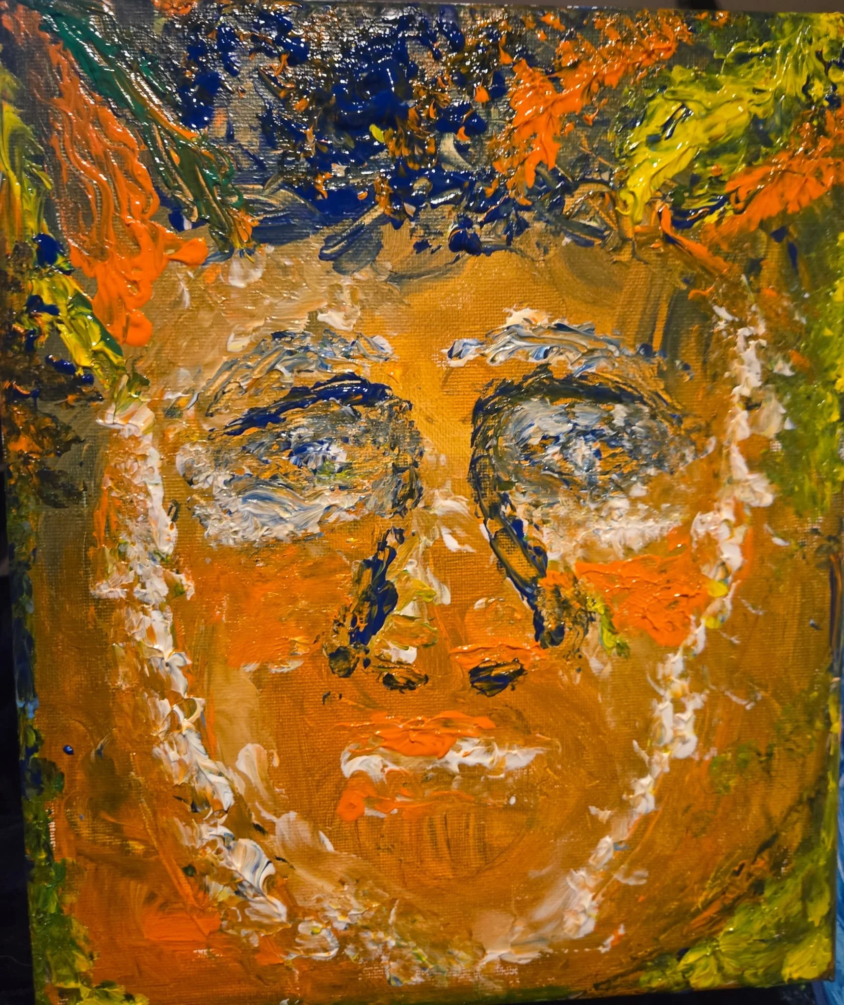 Abstract painting of a woman's face with expressive brushstrokes, featuring eyes with heavy blue eyelids, prominent nose, and lips, surrounded by colorful textured foliage and background in shades of orange, green, blue, and yellow.