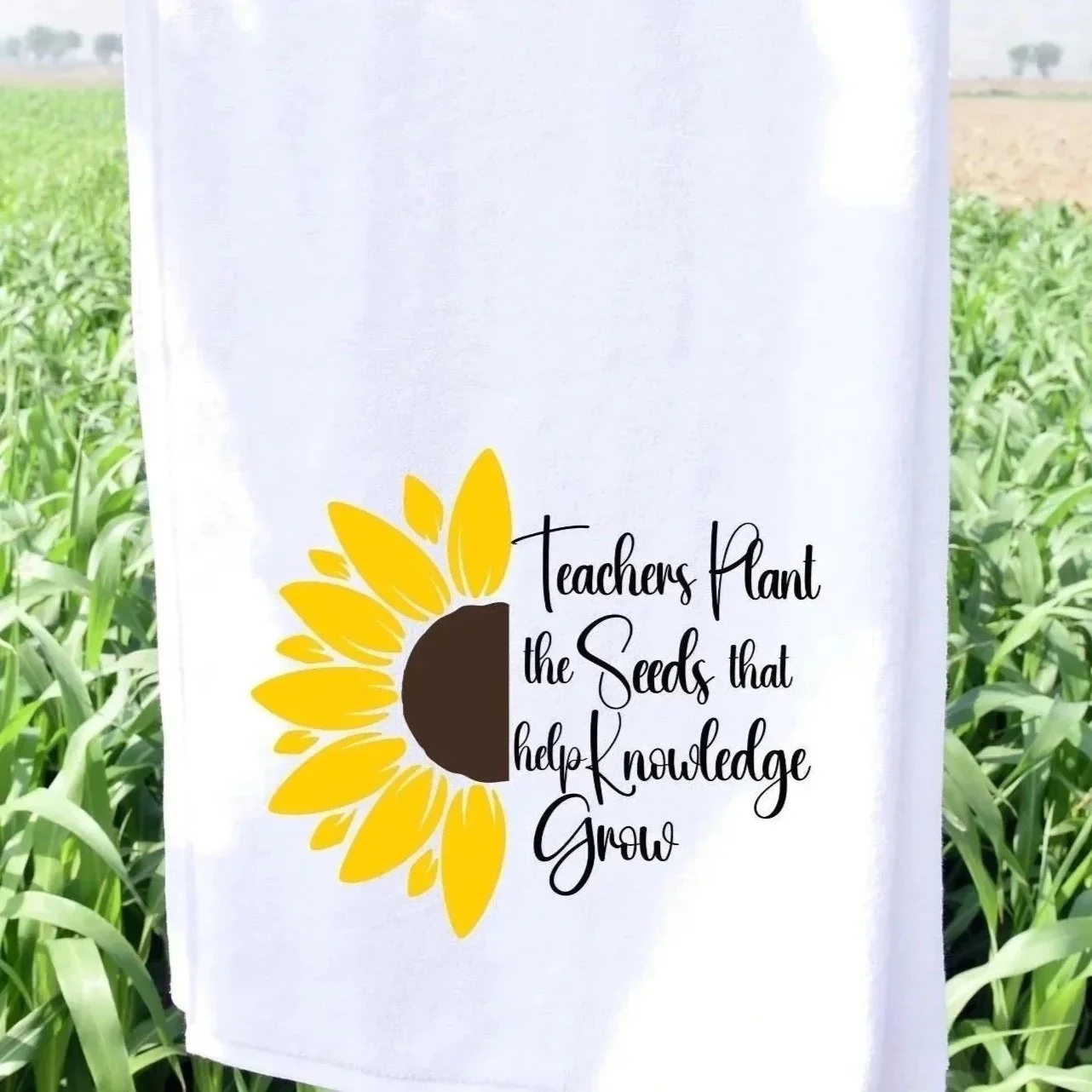 Sunflower graphic and the text "Teachers Plant the Seeds that Help Knowledge Grow" written in black cursive font, placed outdoors among green plants. Perfect for Teachers.