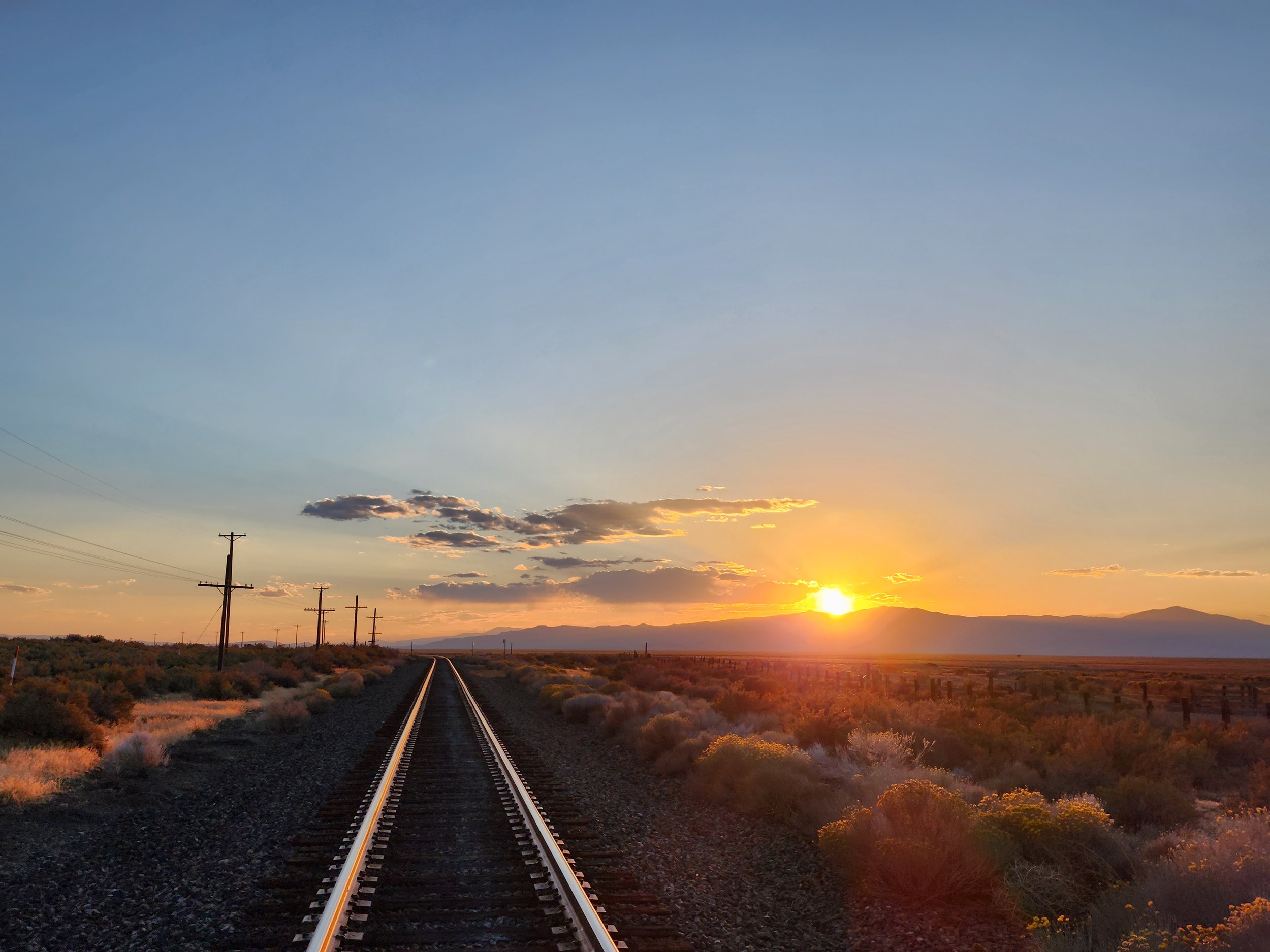 Mountain Sunset beside train tracks