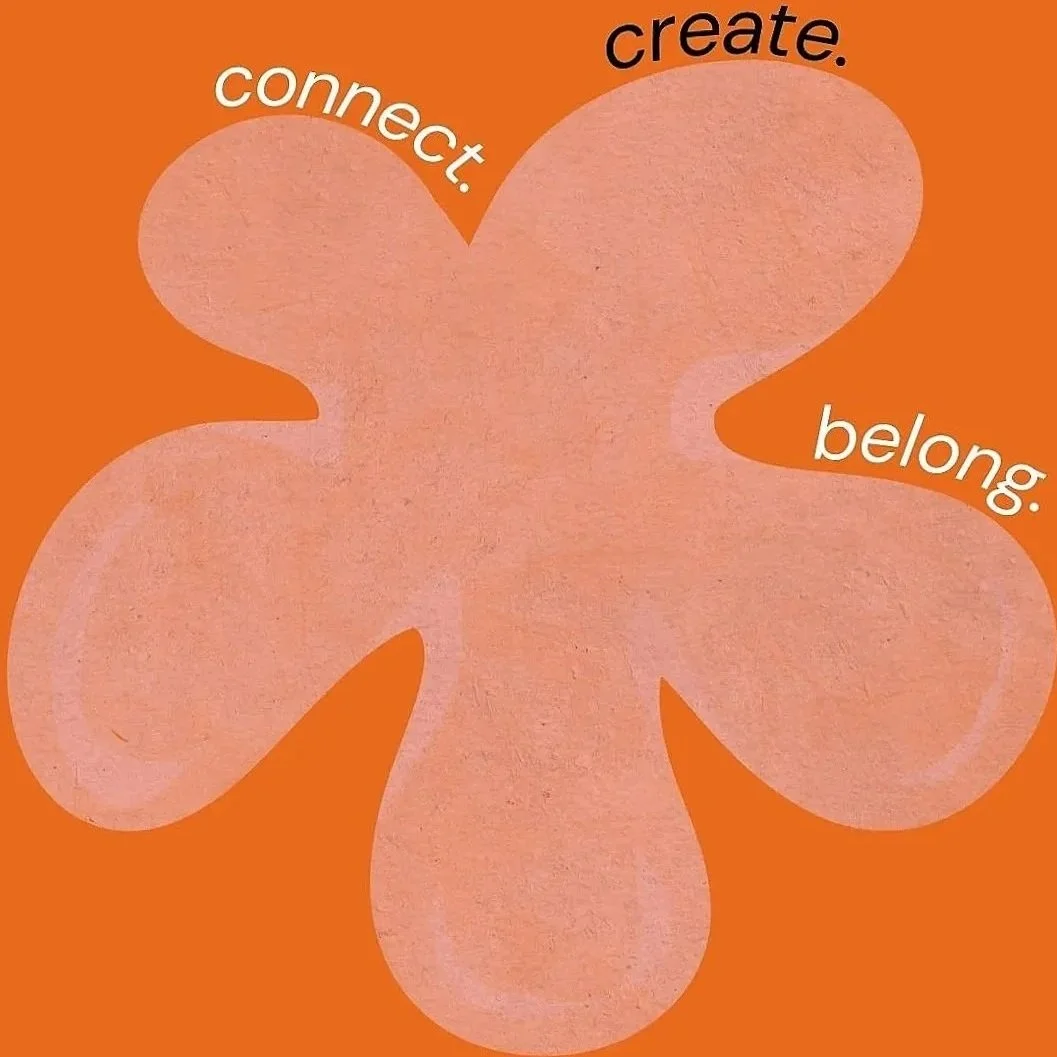 A pink, four-leaf clover shape on an orange background with the words 'connect.', 'create.', and 'belong.' placed on the leaves.