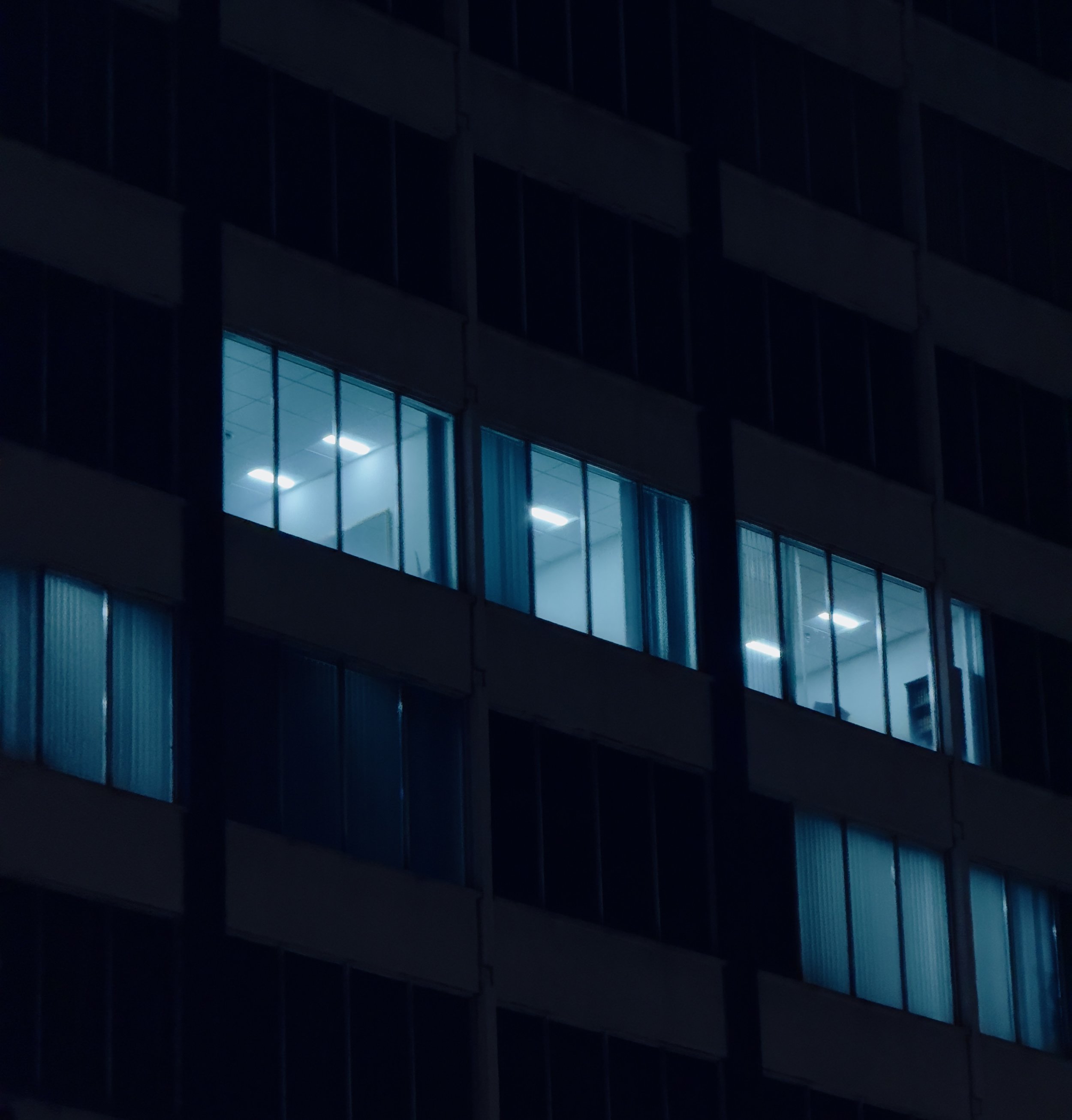 Nighttime view of a modern office building with illuminated windows.