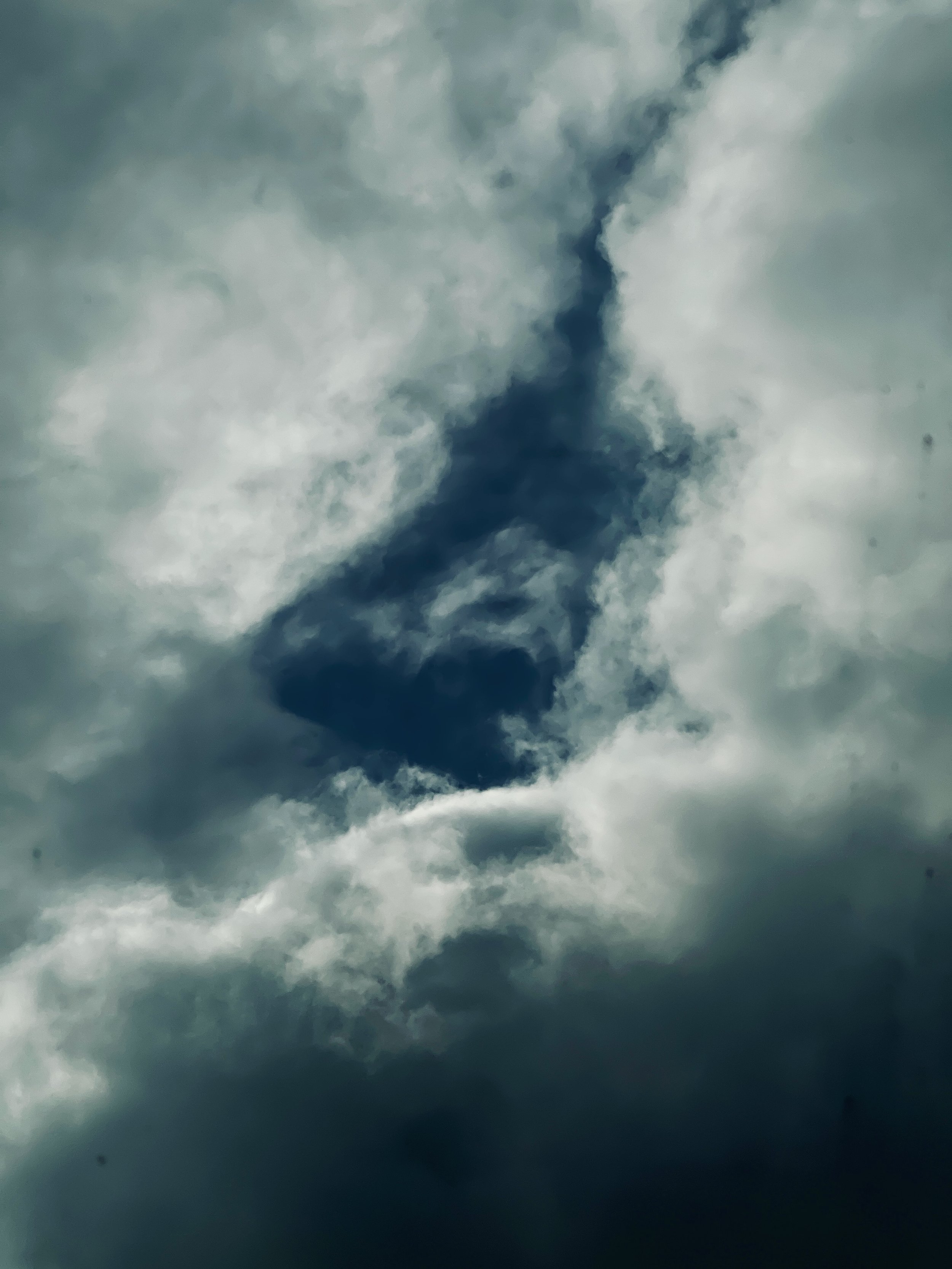 Cloudy sky with a large opening revealing blue sky