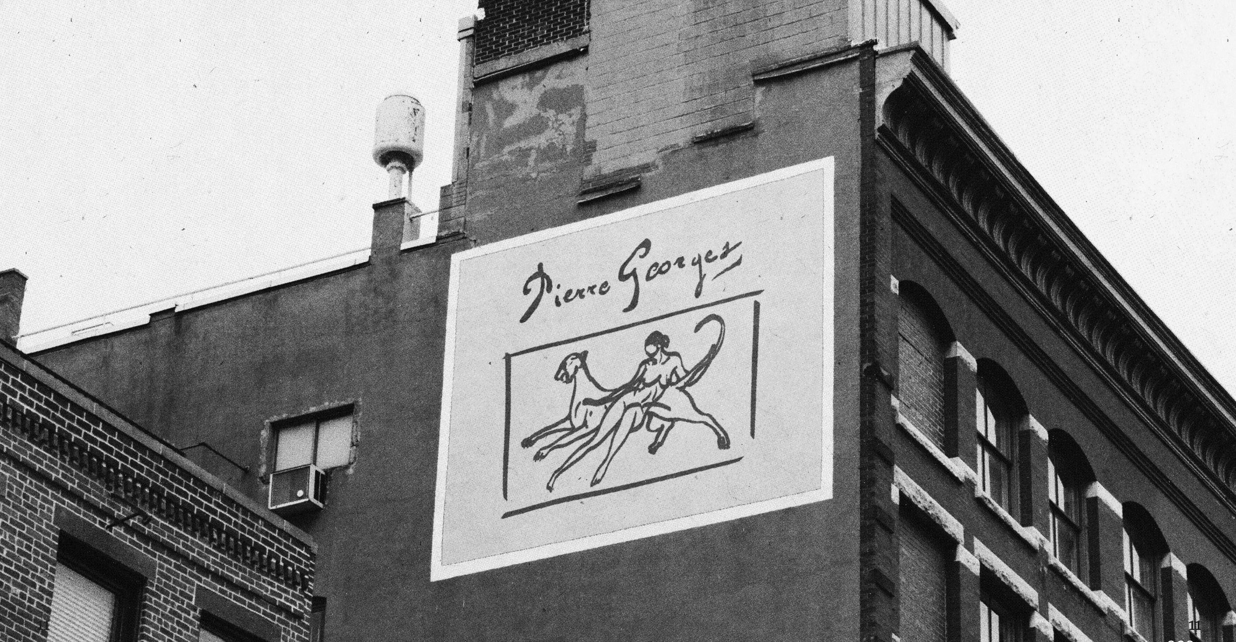 Black and white photo of a building with a large sign that reads 'Pierre Georges' and depicts a woman riding a horse.