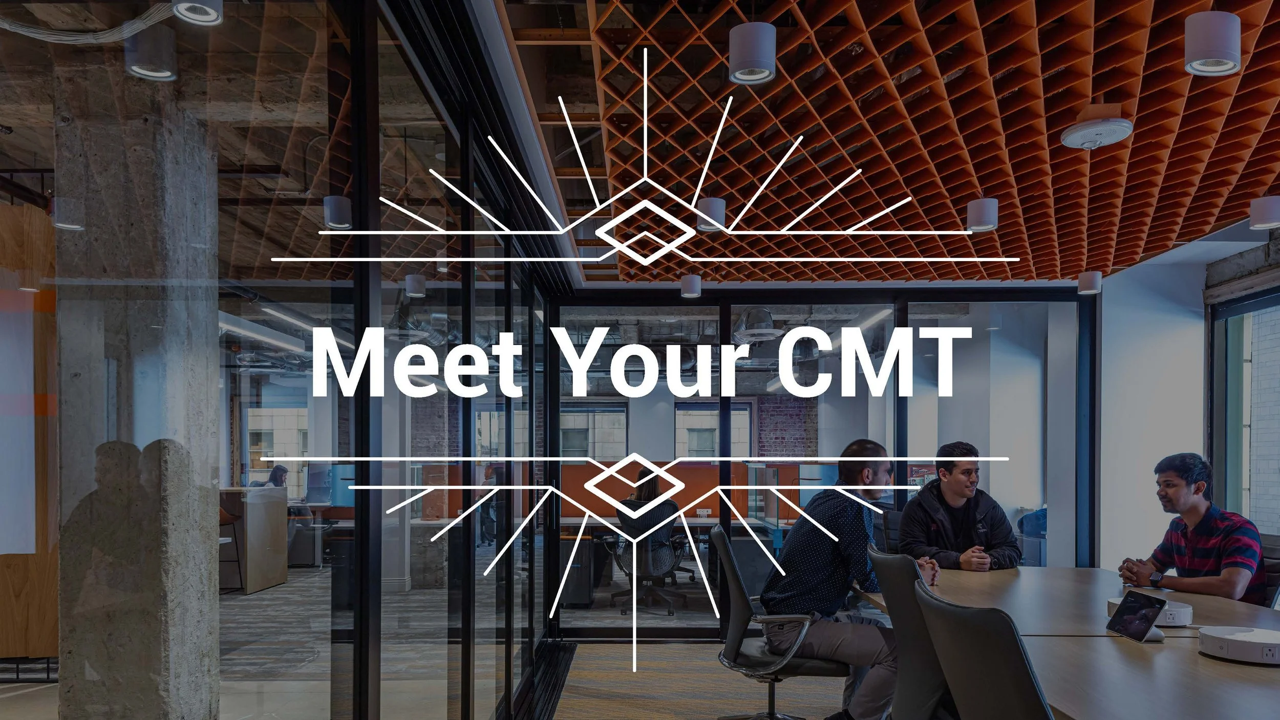 An office meeting room with three young men sitting at a table engaged in conversation, with large windows on the right side. The room has a modern design with glass walls, exposed brick, and a geometric ceiling pattern with mounted lighting. The text overlay says, "Meet Your CMT."