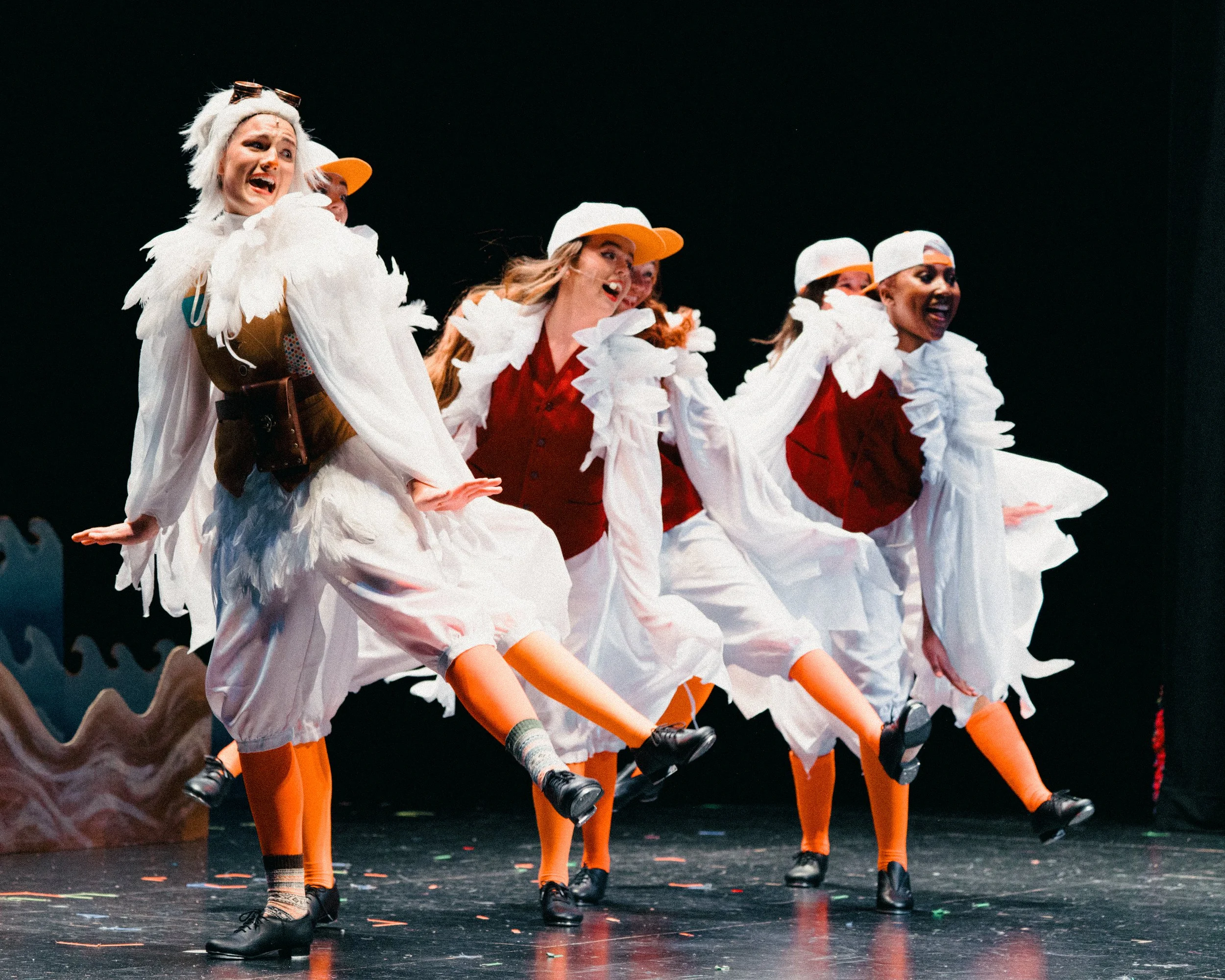 Performers dressed as chickens on stage during a theatrical production.