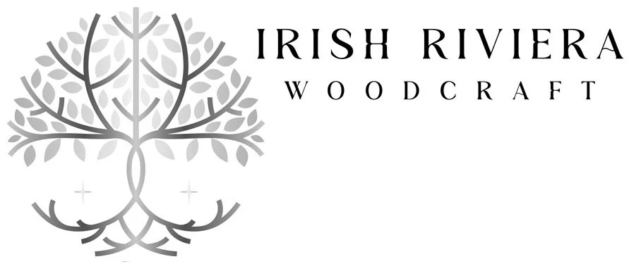 Logo for Irish Riviera Woodcraft featuring a stylized tree with roots, branches, and leaves in gray, and the text 'Irish Riviera Woodcraft' in black.