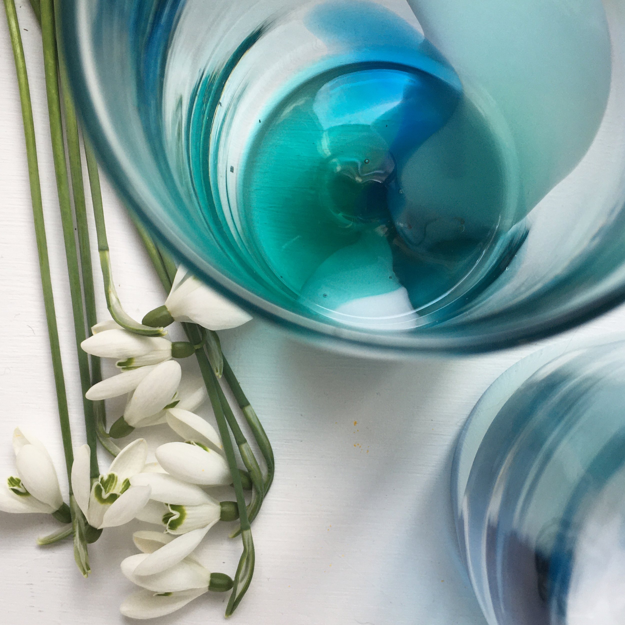 Colour POP cups with white flowers and green stems arranged on a white surface.