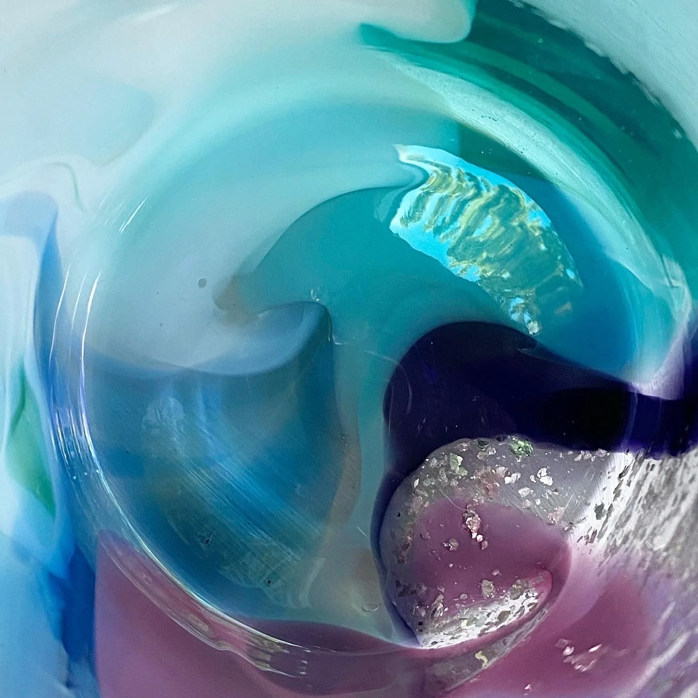 Close-up of a  colour pop cup, colorful, glossy, abstract glass  with swirling patterns in shades of blue, green, purple, and hints of yellow.