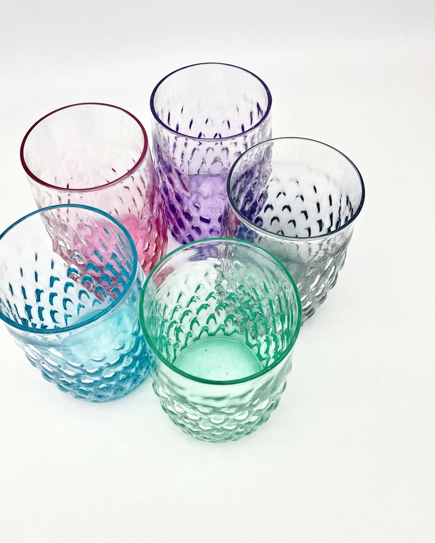 Six colorful Gem textured drinking glasses arranged on a white surface, with colors including pink, purple, blue, green, and clear.