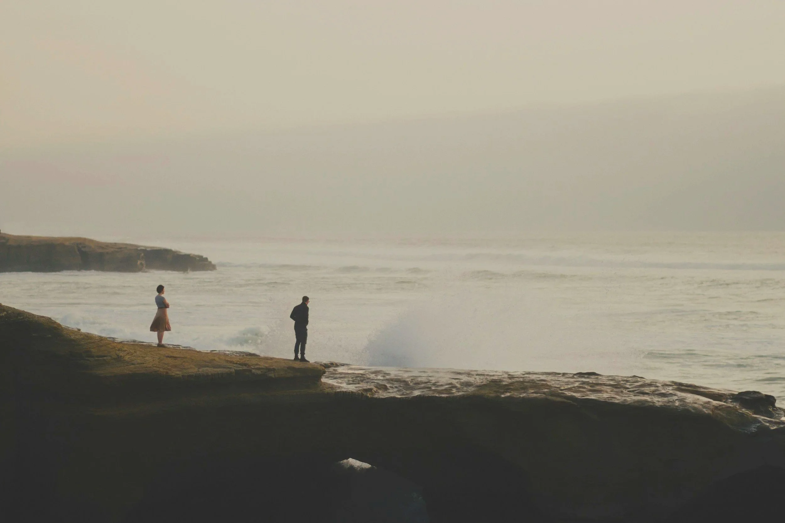 Two people standing on a misty shoreline