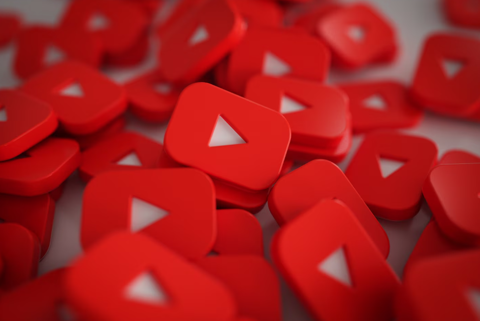 A pile of red YouTube play button icons with white triangles in the center.