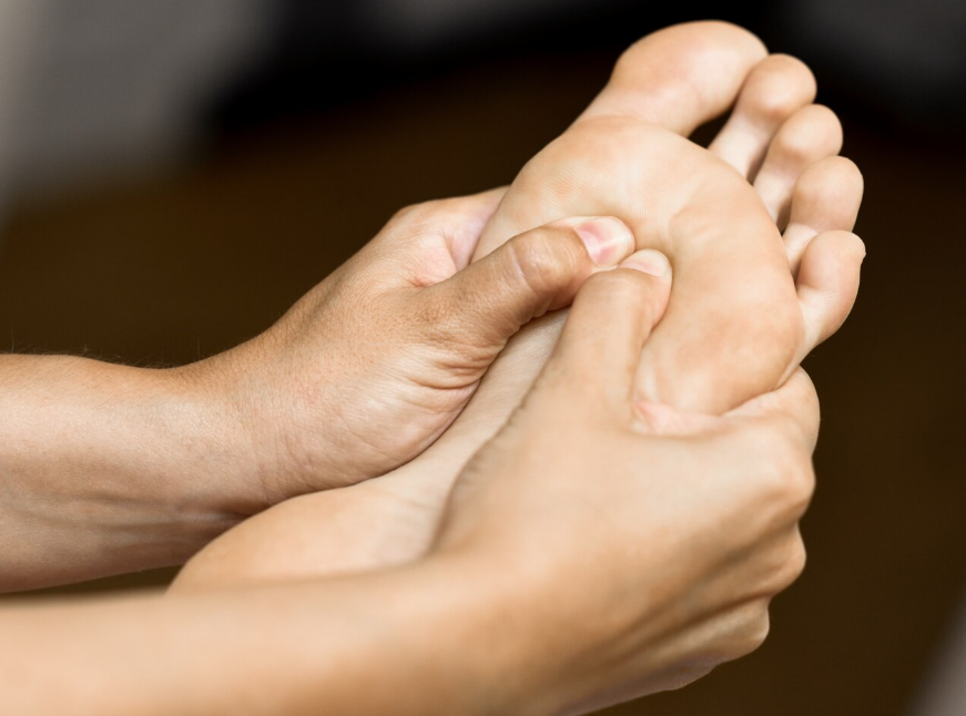 A person giving a foot massage or reflexology treatment