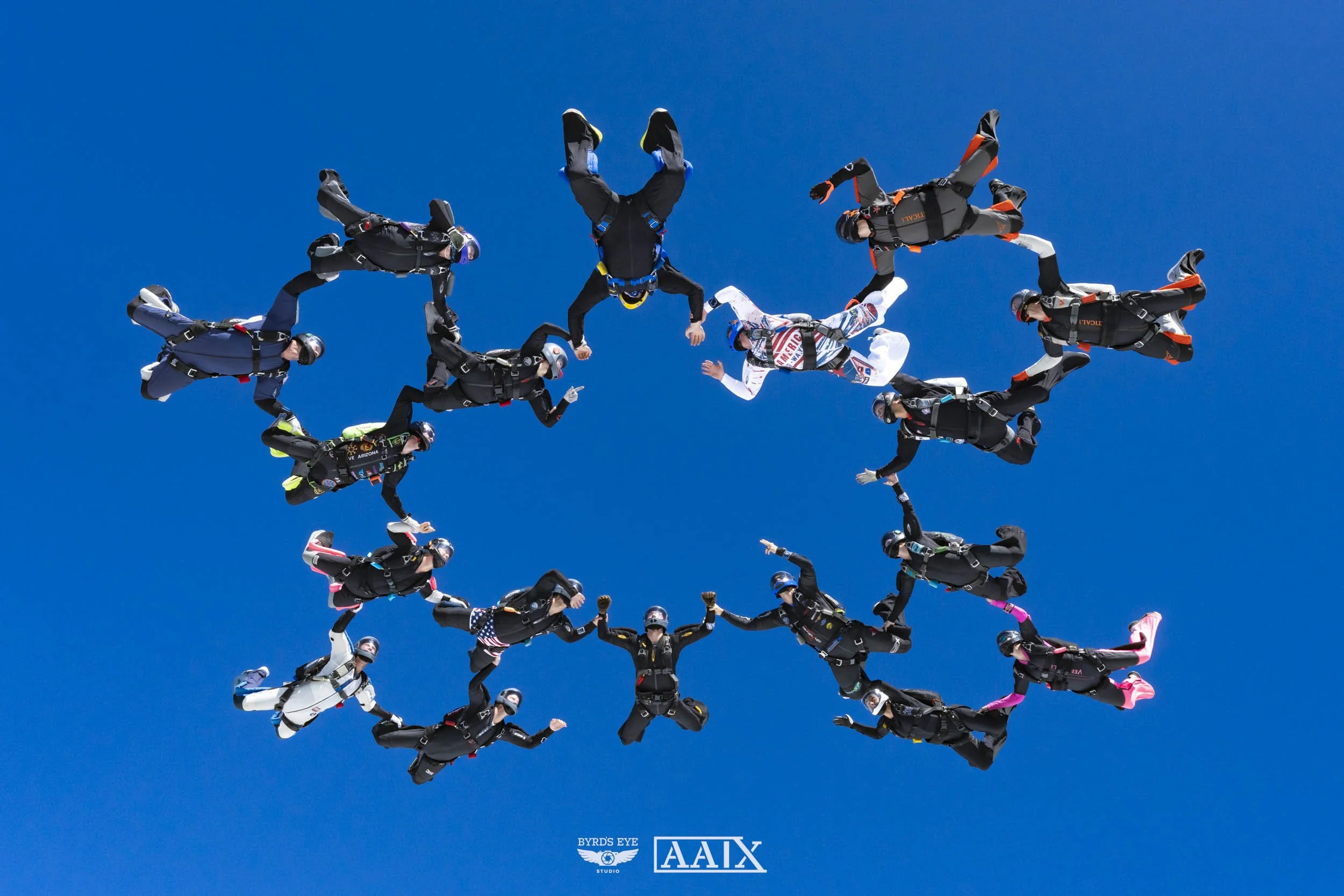 Skydivers forming the American flag in the sky with a bright blue background.