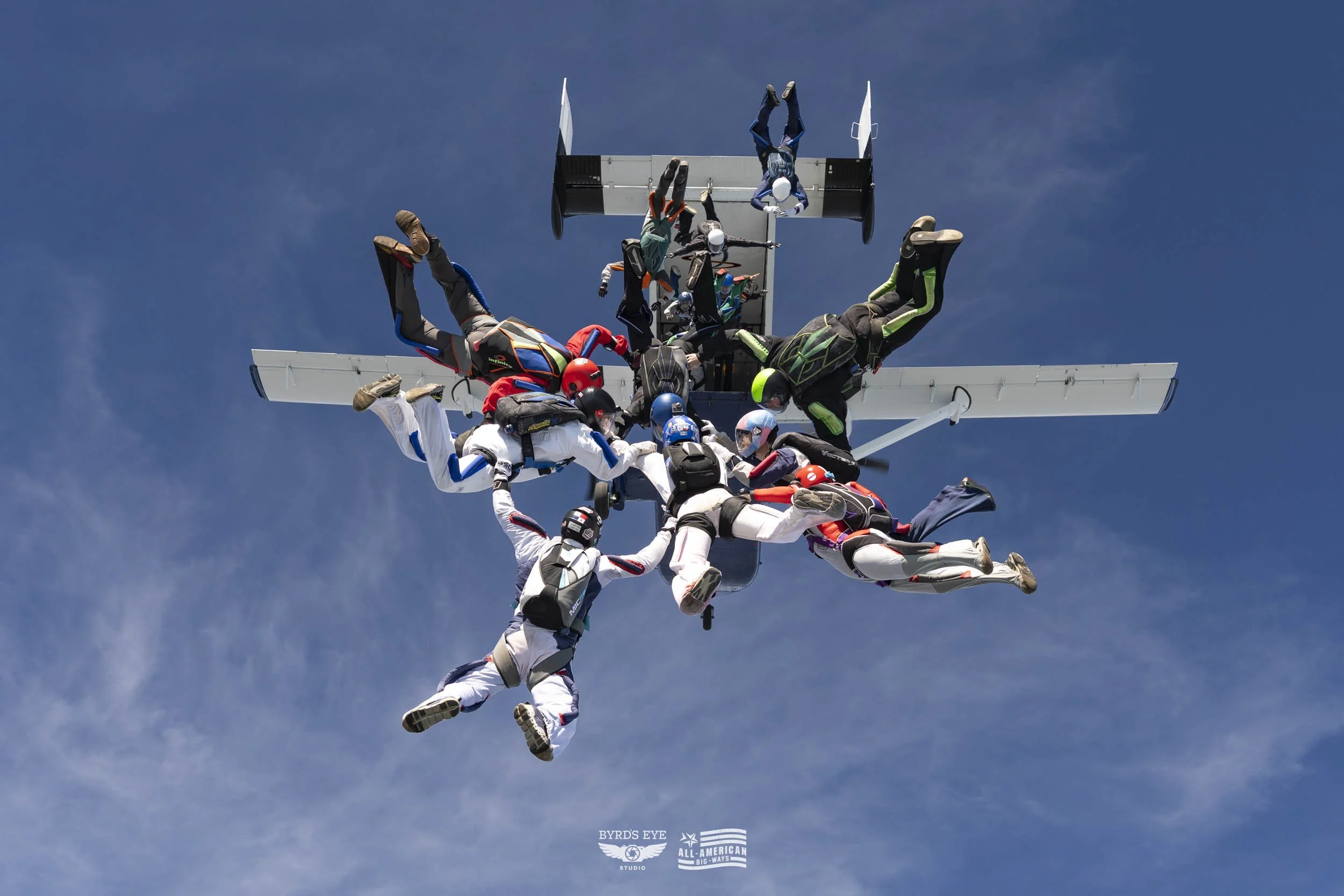 Skydivers forming a star shape as they freefall through the sky.