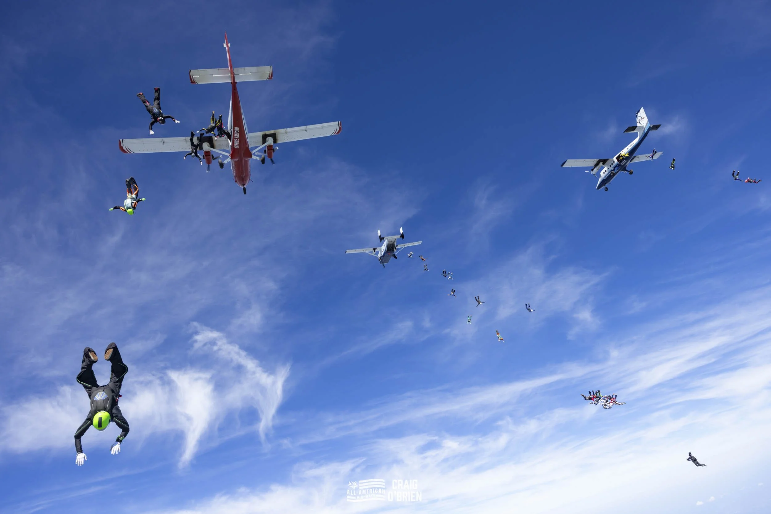 Skydivers jumping from airplanes in the sky.