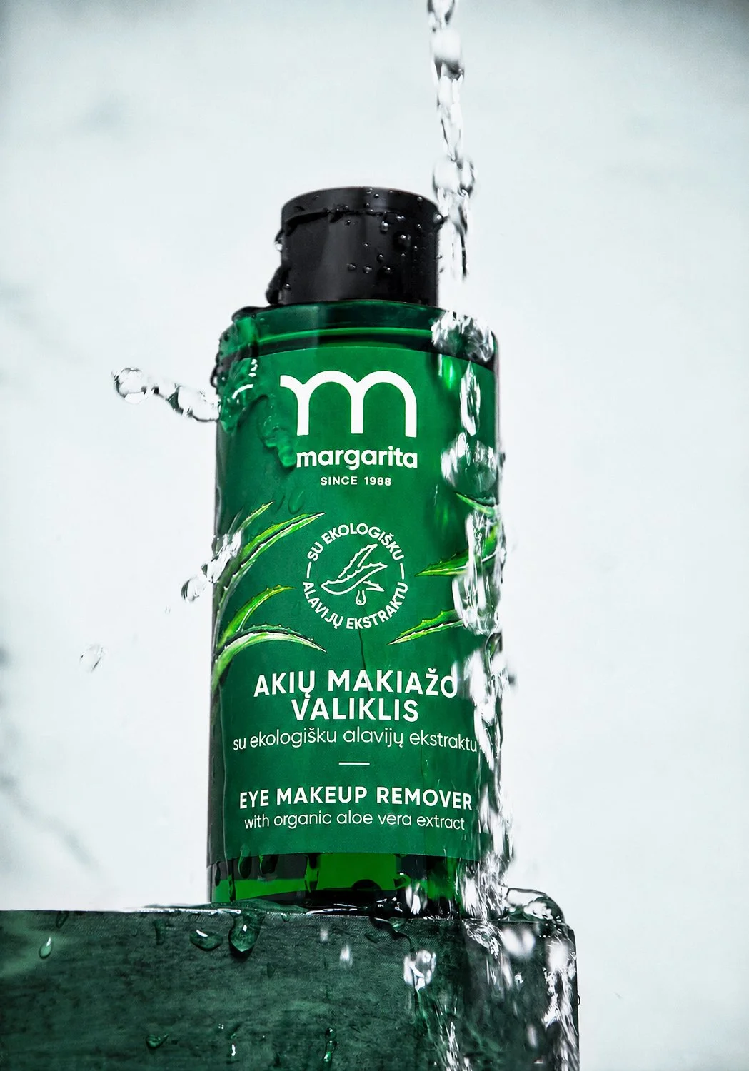 Creative product visual featuring a green eye makeup remover bottle from Margarita, a Lithuanian skincare and cosmetics brand.
