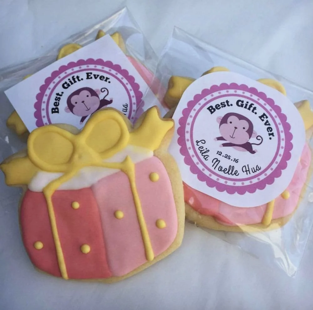 Decorated sugar cookies shaped like a gift box with a bow and a monkey face, with matching gift tags reading "Best. Gift. Ever."