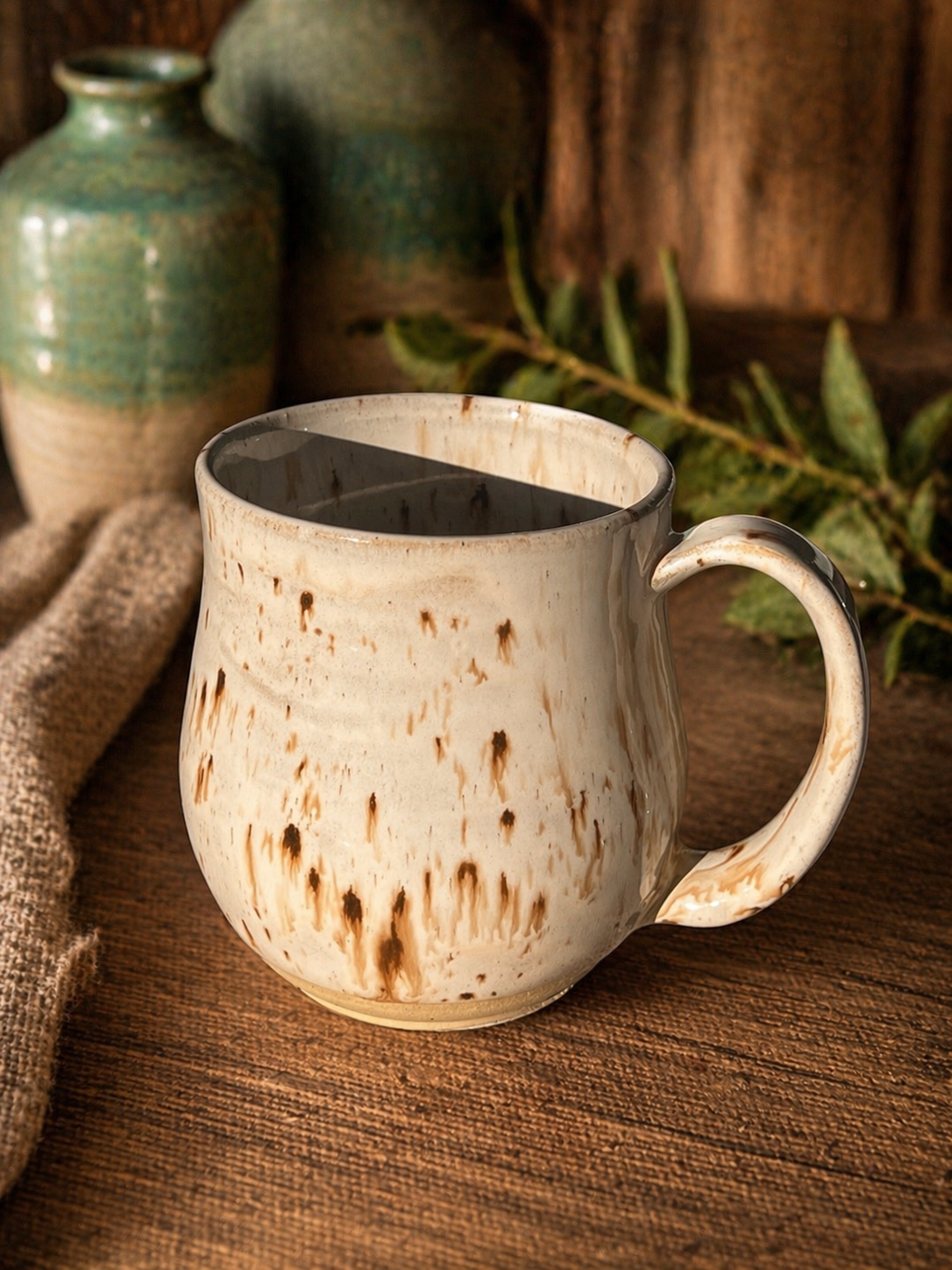 A ceramic mug with a beige and brown speckled pattern.