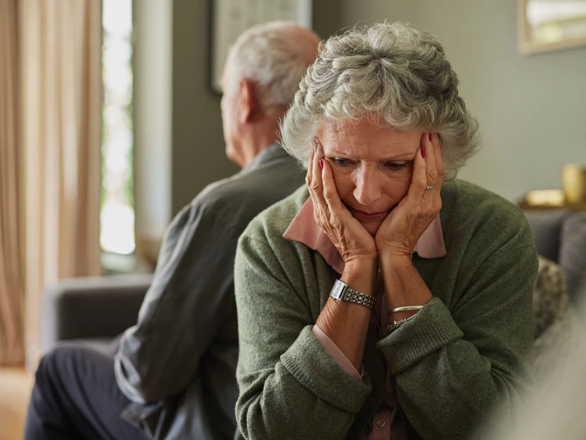 older man and woman back to back frustrated with each other